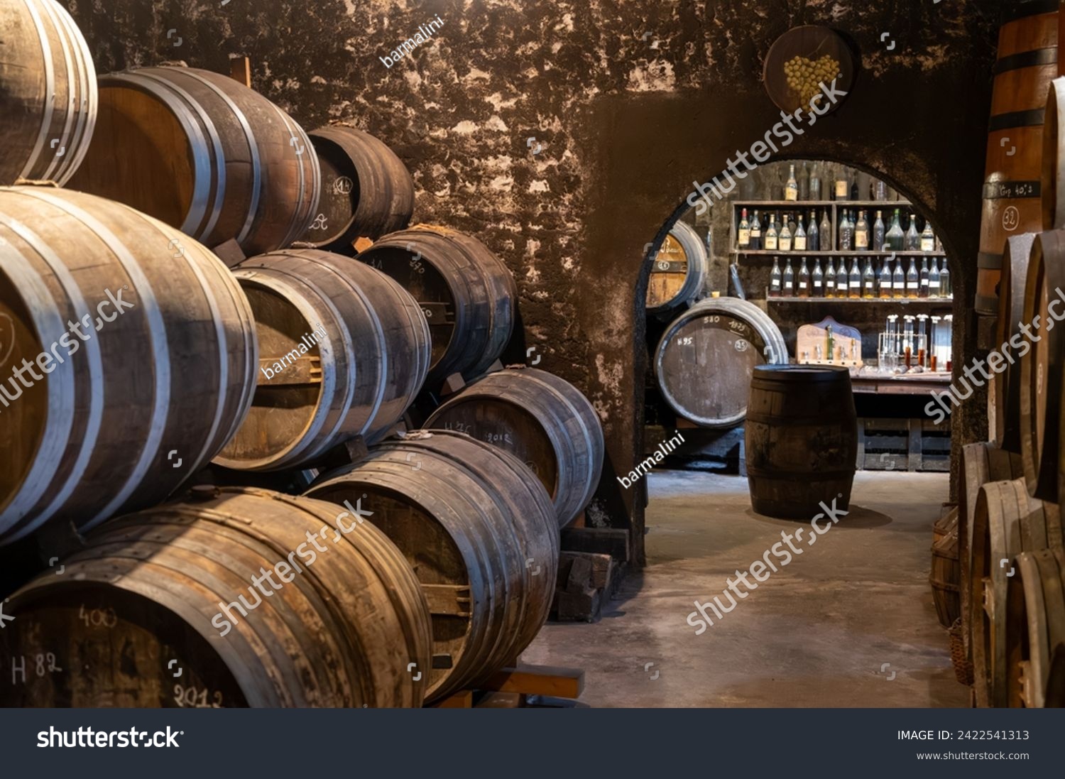 Aging process of cognac spirit in old dark French oak barrels in cellar in distillery house, Cognac white wine region, Charente, Segonzac, Grand Champagne, France #2422541313