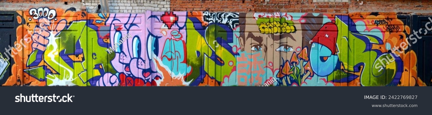 The old wall decorated with paint stains in the style of street art culture. Colorful background of full graffiti painting artwork with bright aerosol outlines on wall. Colored background texture #2422769827