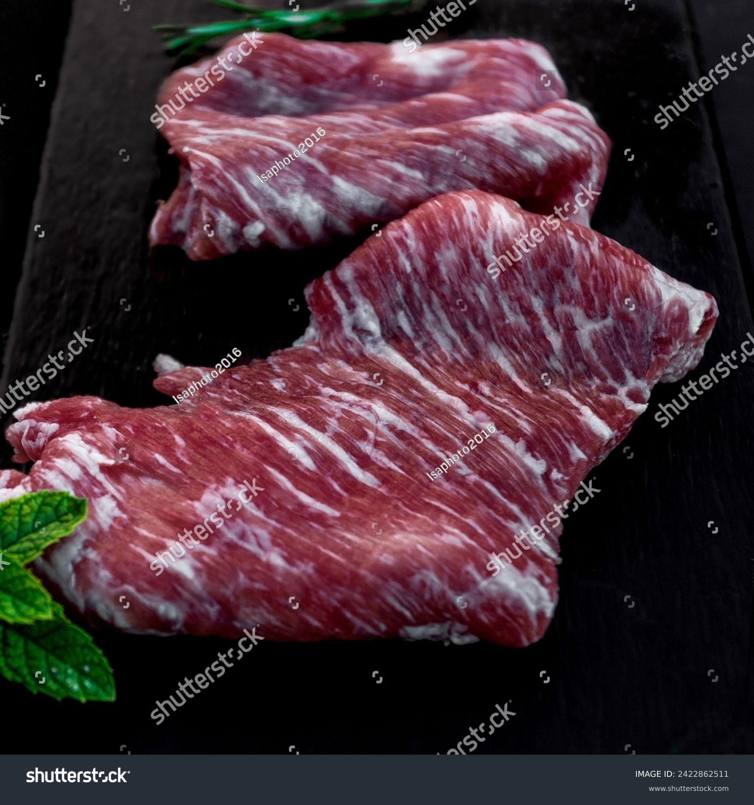 Raw iberian pork meat on black slate secreto ibérico #2422862511