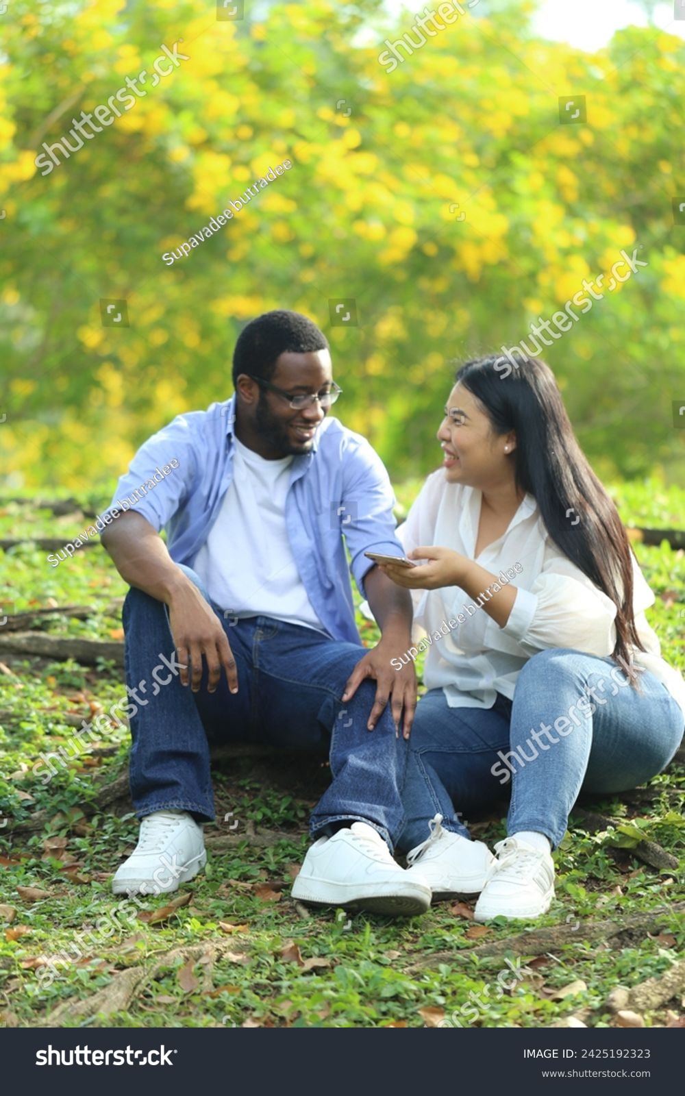Couple, black husband and Asian wife,  happily hugging and talking in the garden #2425192323