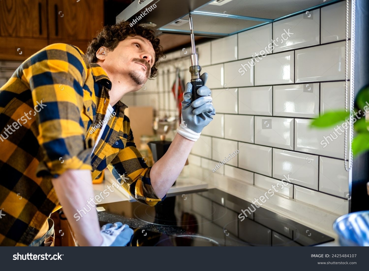 Latino man fixing aspirator in the kitchen. #2425484107