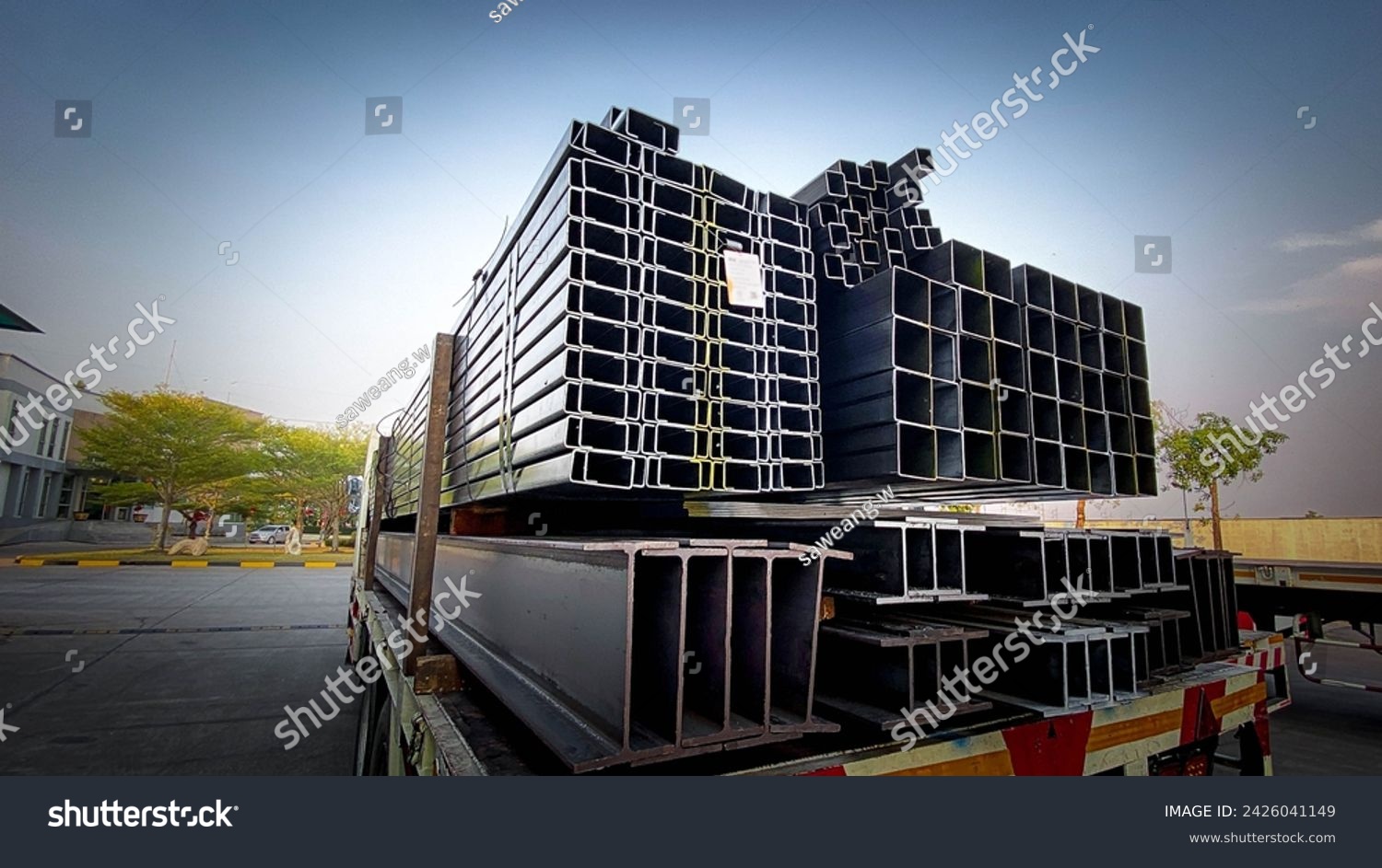 Trucks with long trailers carrying steel bars for building construction. Construction steel is ready to be delivered to the customer.Steel in thailand #2426041149