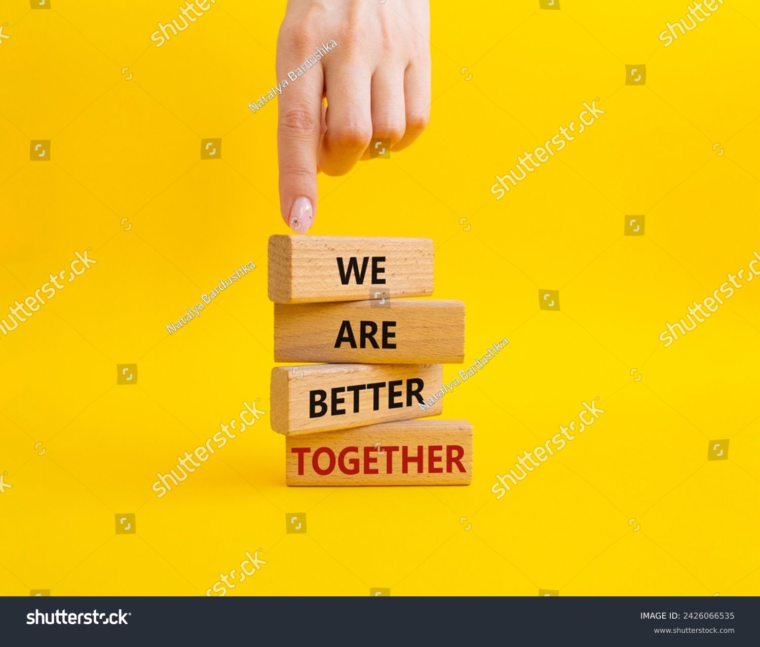 We are better together symbol. Wooden blocks with words We are better together. Beautiful yellow background. Businessman hand. We are better together concept. Copy space. #2426066535