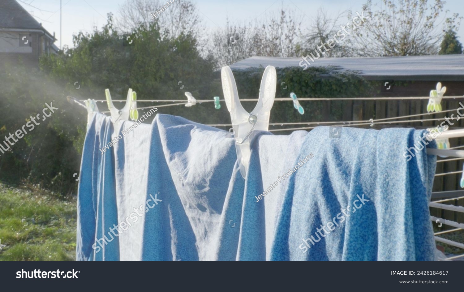 Evaporation of water of clothes drying in the backyard. #2426184617