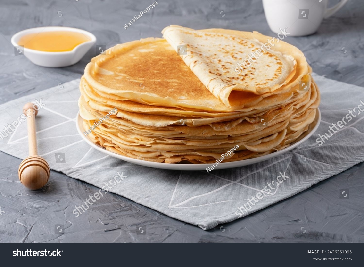 Stack of traditional russian pancakes blini on gray background with copy space. Homemade russian thin pancakes blini. Russian food, russian kitchen #2426361095