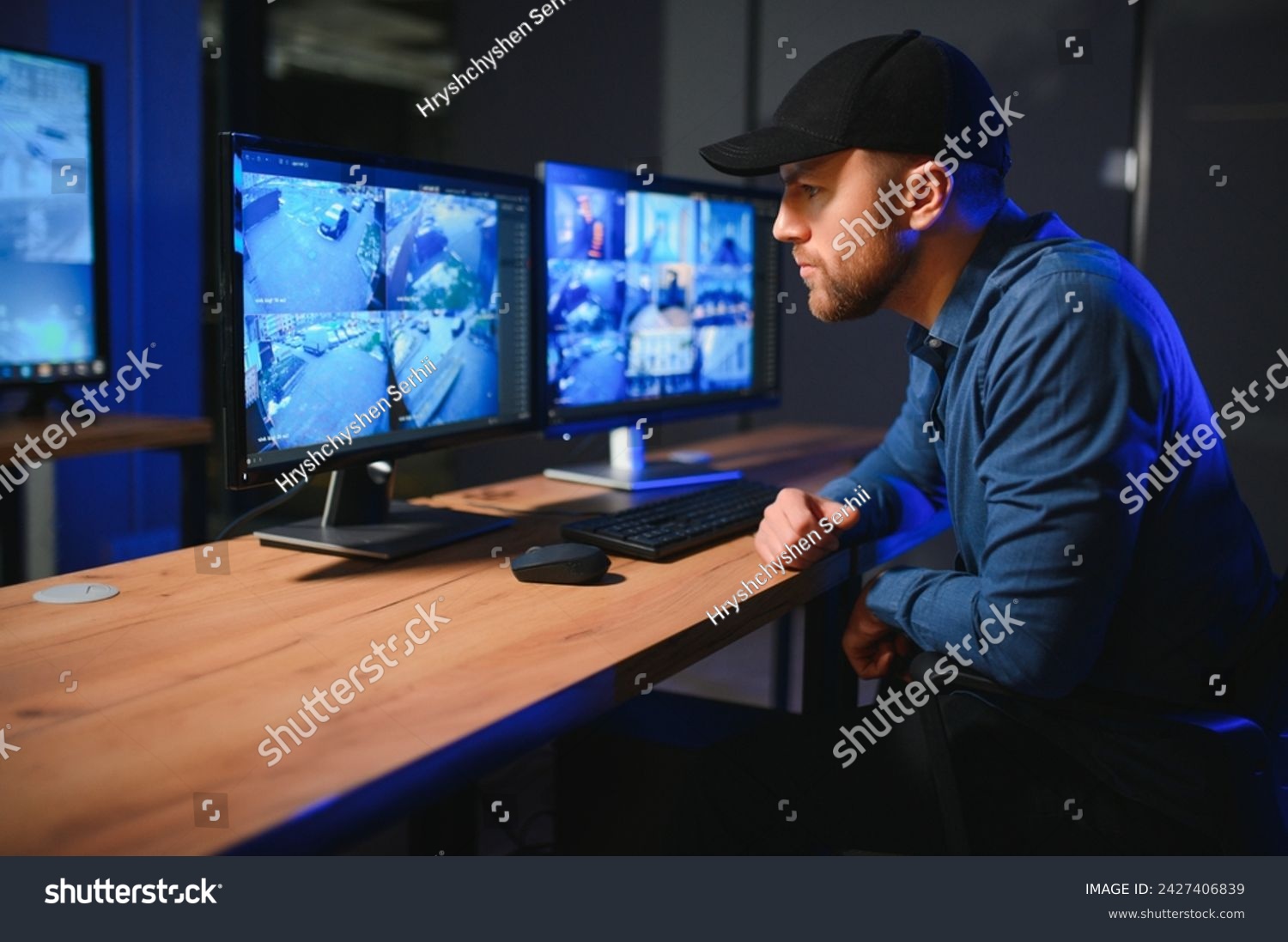 Male security guard monitoring modern CCTV cameras indoors. #2427406839