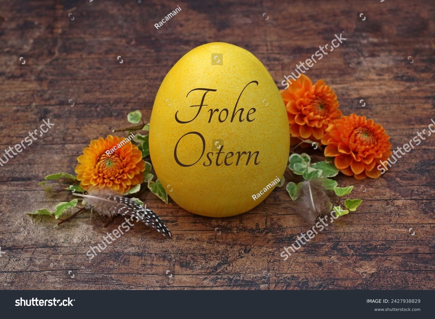 Happy Easter: Inscribed Easter egg on wooden background with flowers. German inscription reads Happy Easter. #2427938829