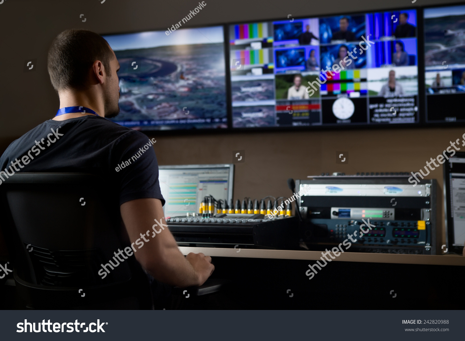 TV engineer at editor in studio. TV editor working with vision mixer in a television broadcast gallery.Man sat at a vision mixing panel in a television studio gallery #242820988