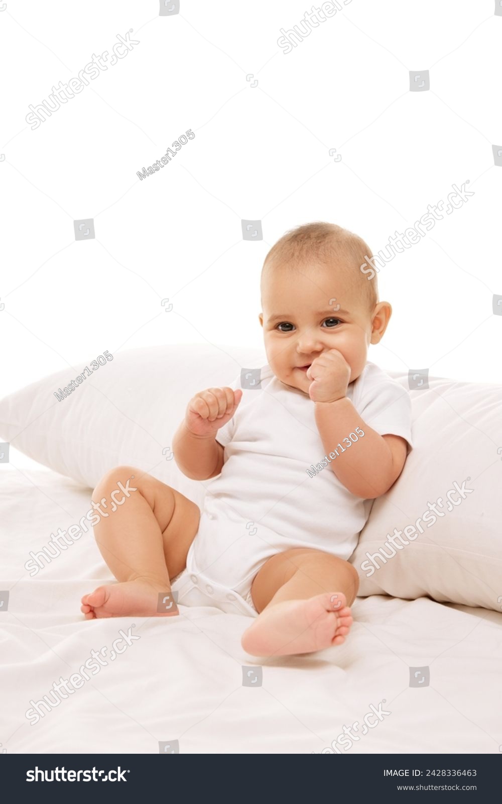 Portrait of beautiful little baby girl, toddler in onesie posing on bed against white background. Healthcare and education. Concept of childhood, family, care, motherhood, infancy, heath #2428336463