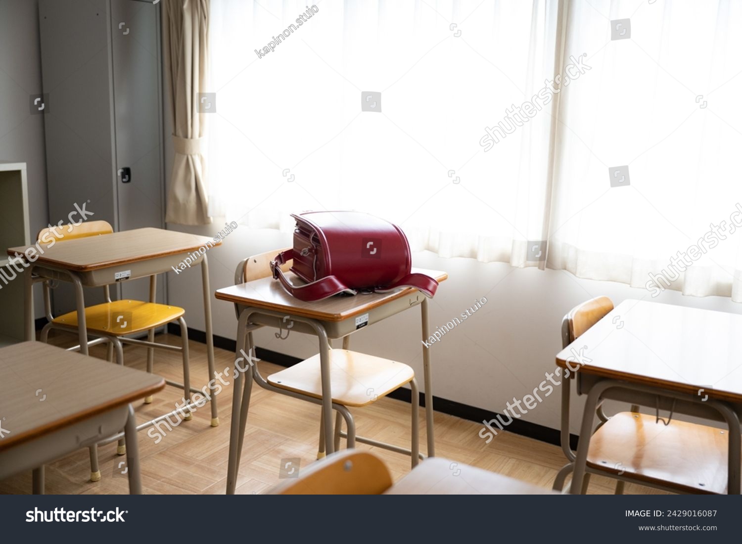 A school bag on a desk in a classroom at a Japanese elementary school during the daytime. #2429016087