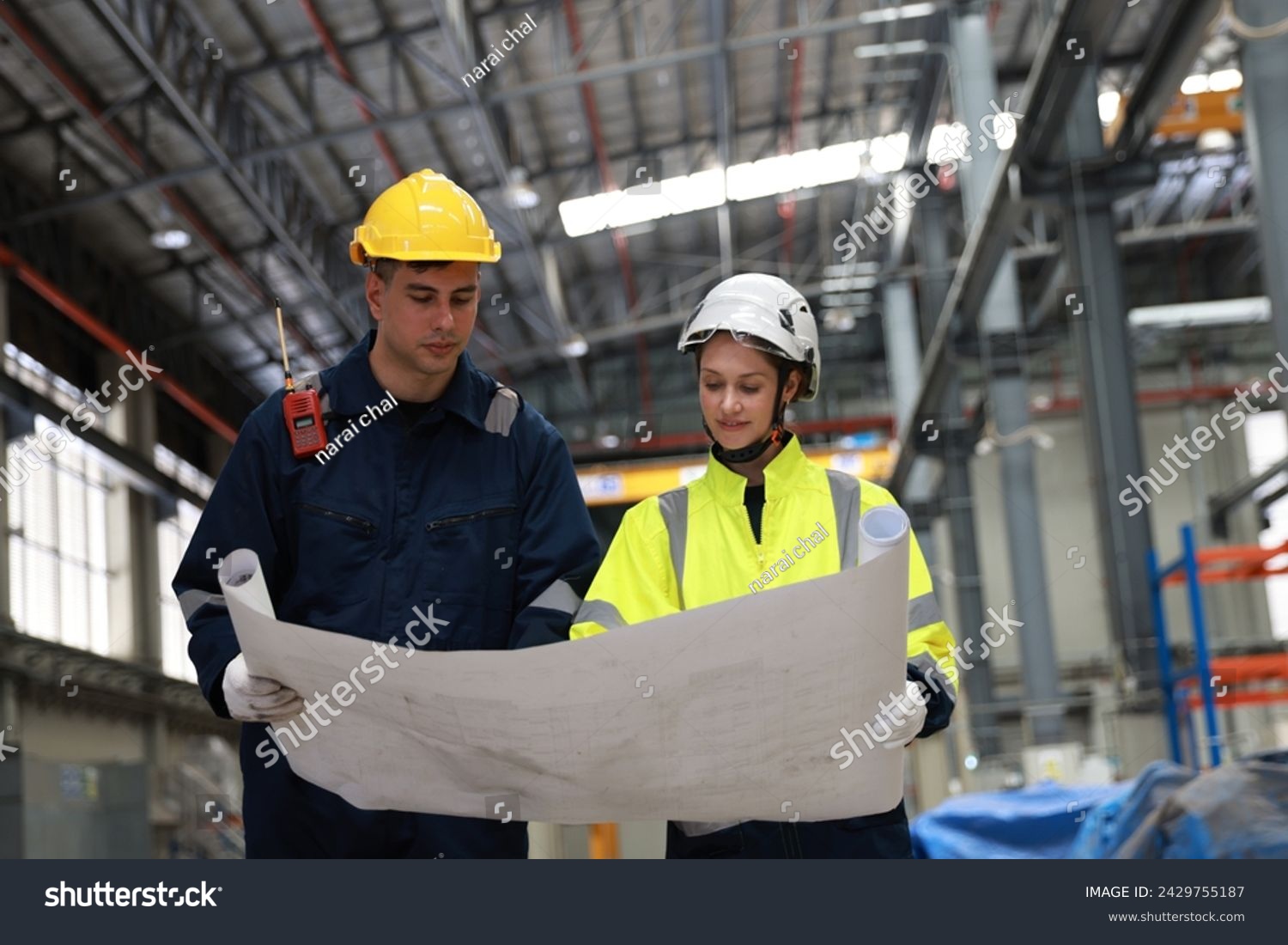 Male and female rail engineer working with blueprint drawing in electric train garage  #2429755187