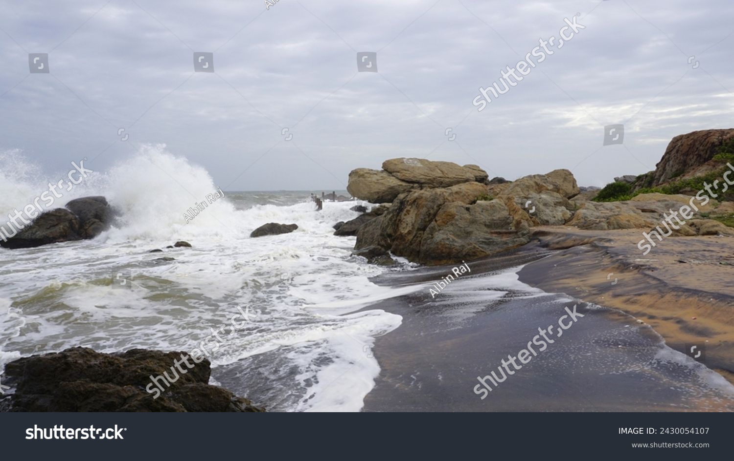 Beautiful rocky shore of muttom beach with sea waves in yellow and black sand. #2430054107
