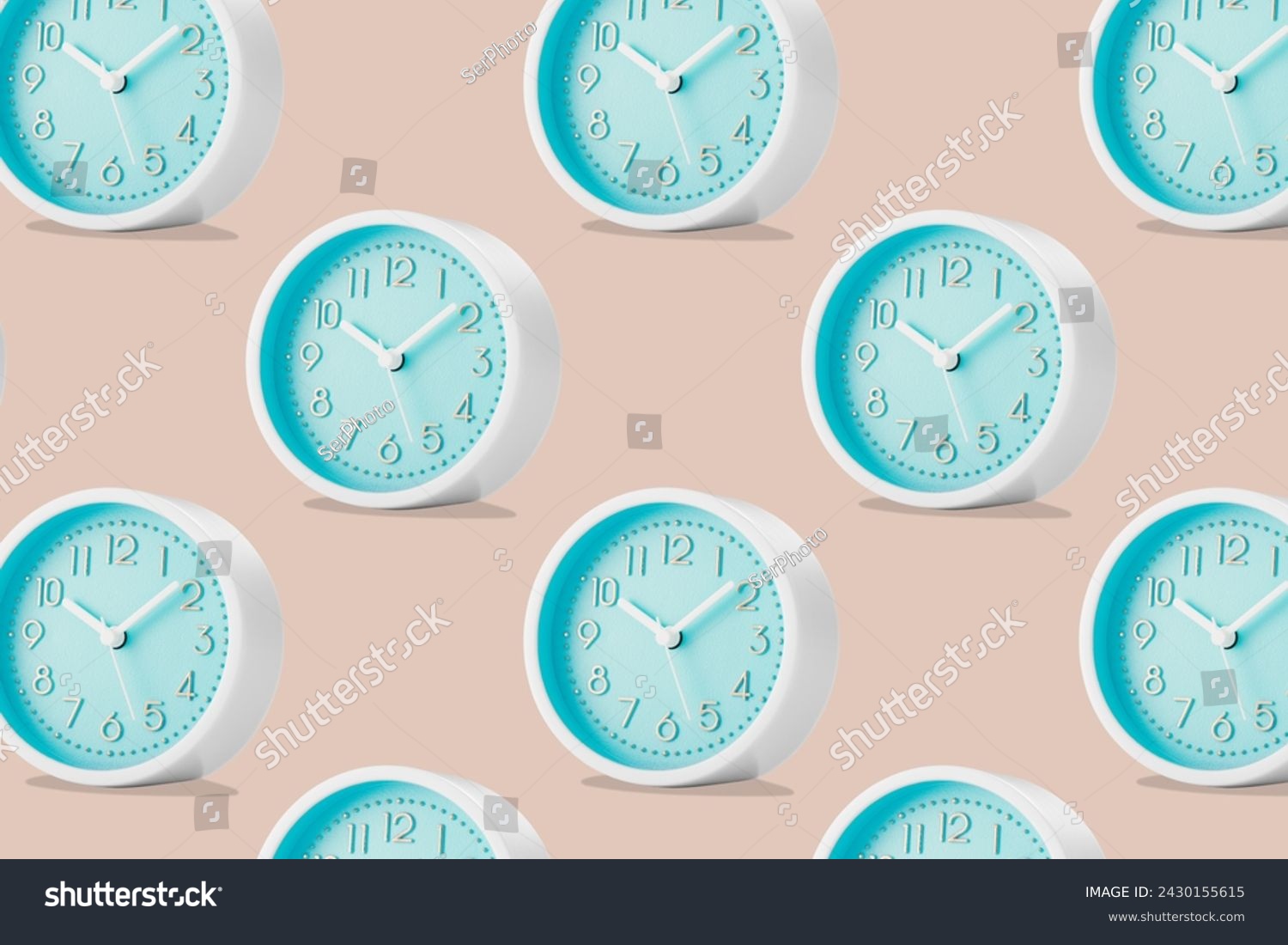 A large group of round analog table clocks with a blue dial on a beige plain background. Low angle view. #2430155615