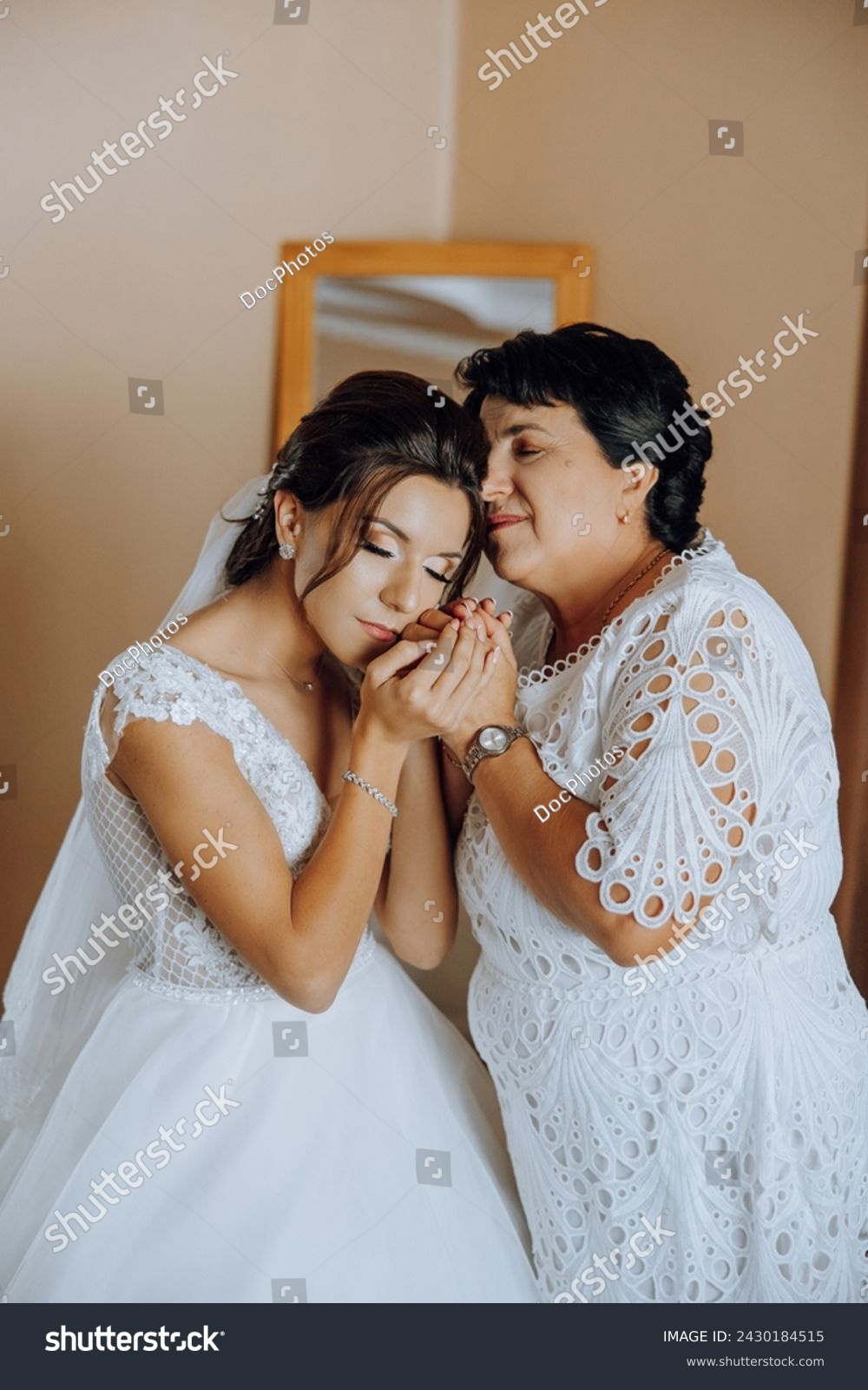 A beautiful and happy mother and her daughter, the bride, are standing next to each other. The best day for parents. Tender moments at the wedding. #2430184515