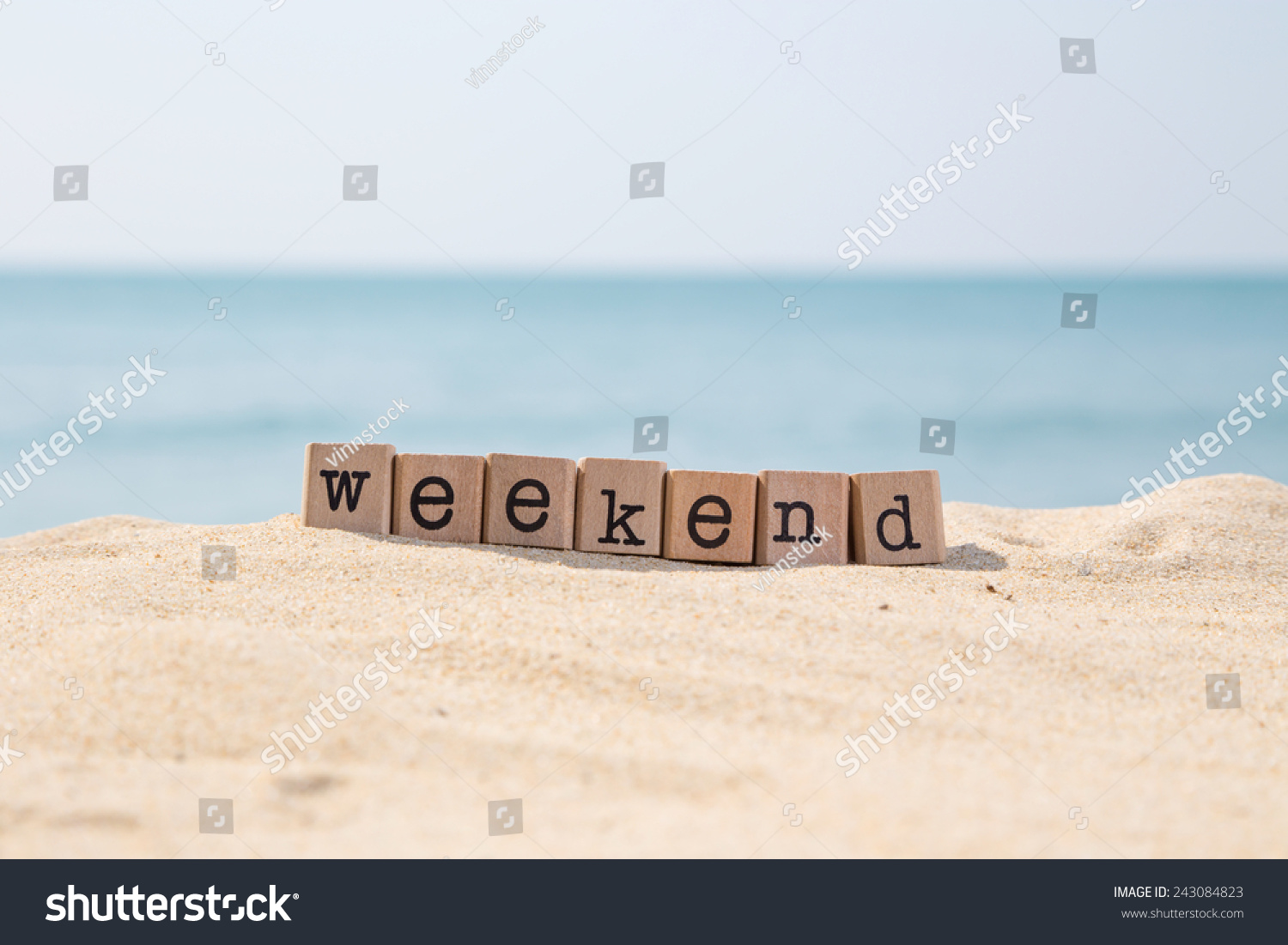 Weekend word on wood rubber stamps stack on the sand beach for vacation and summer season concept, beautiful ocean view during daytime on a sunny day with blue sky on background #243084823