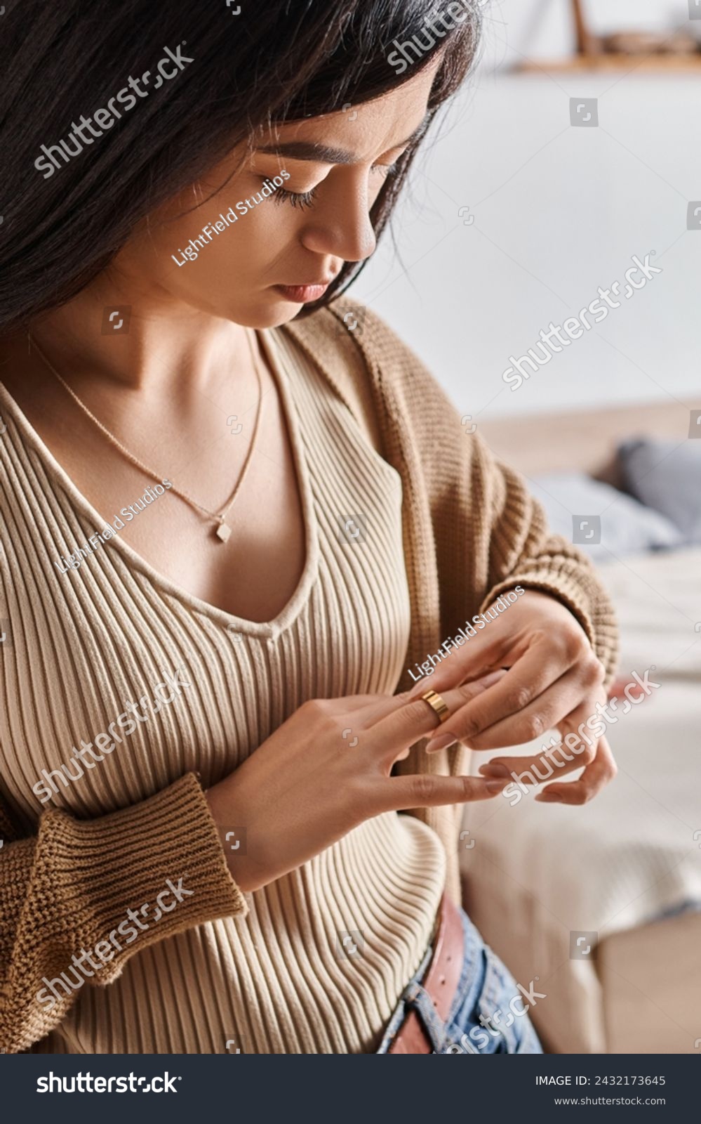 young asian woman taking off wedding ring in sign of divorce, relationship difficulties concept #2432173645