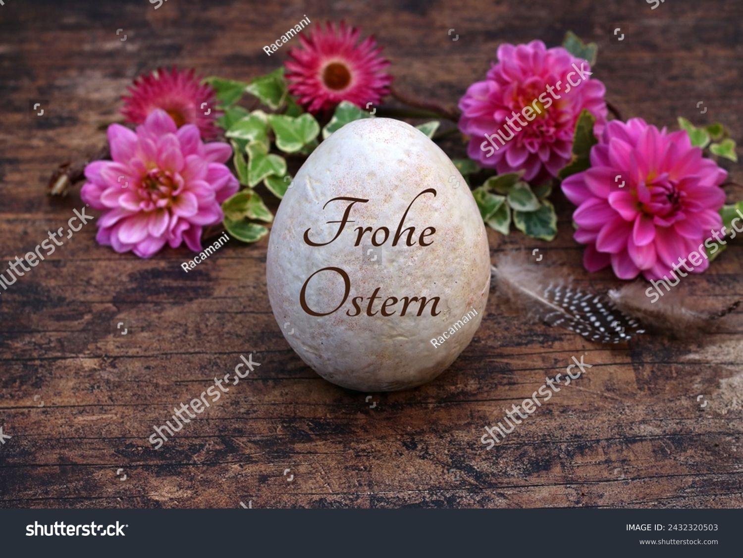 Happy Easter: Inscribed Easter egg with flowers and chicken feathers on wooden background. German inscription translated means Happy Easter. #2432320503
