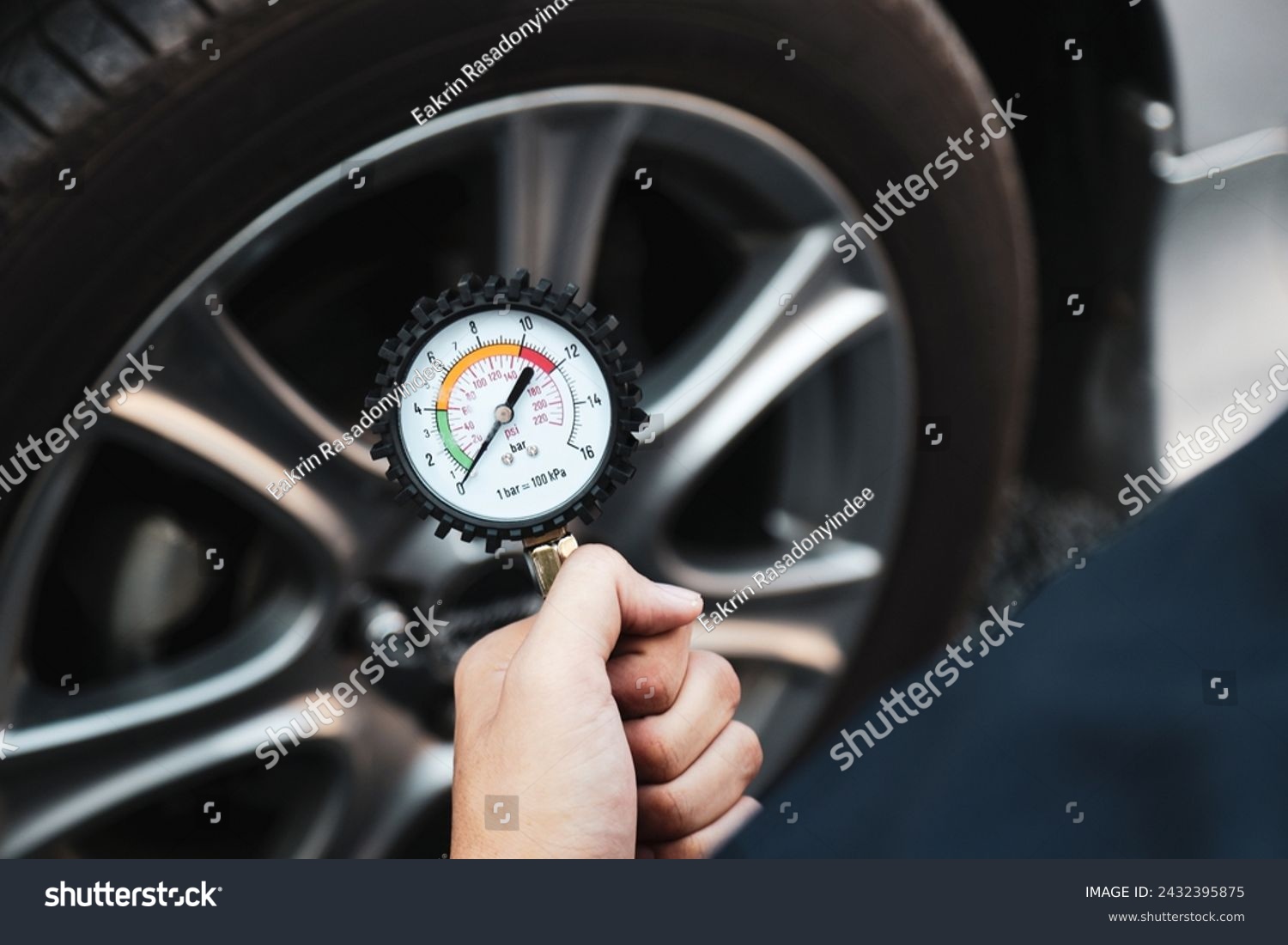 Hand car mechanic holding car tire pressure check equipment tool to checking low tire pressure inflating tires to or refill or air inflate to safety and car care service maintenance inspection. #2432395875