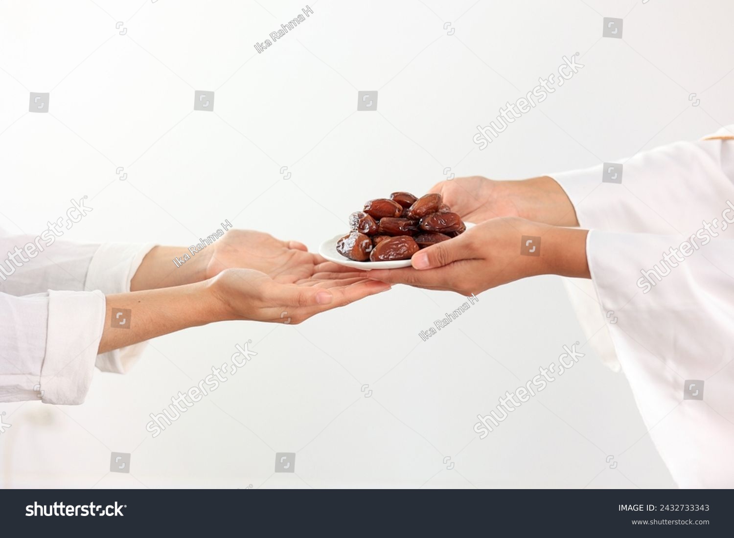 Concept Giving or Charity during Ramadhan Holy Month, Female Muslim Hand Over A Plate of Dates Fruit Kurma to Other. Ifthar and Ramadan Kareem Concept.  #2432733343