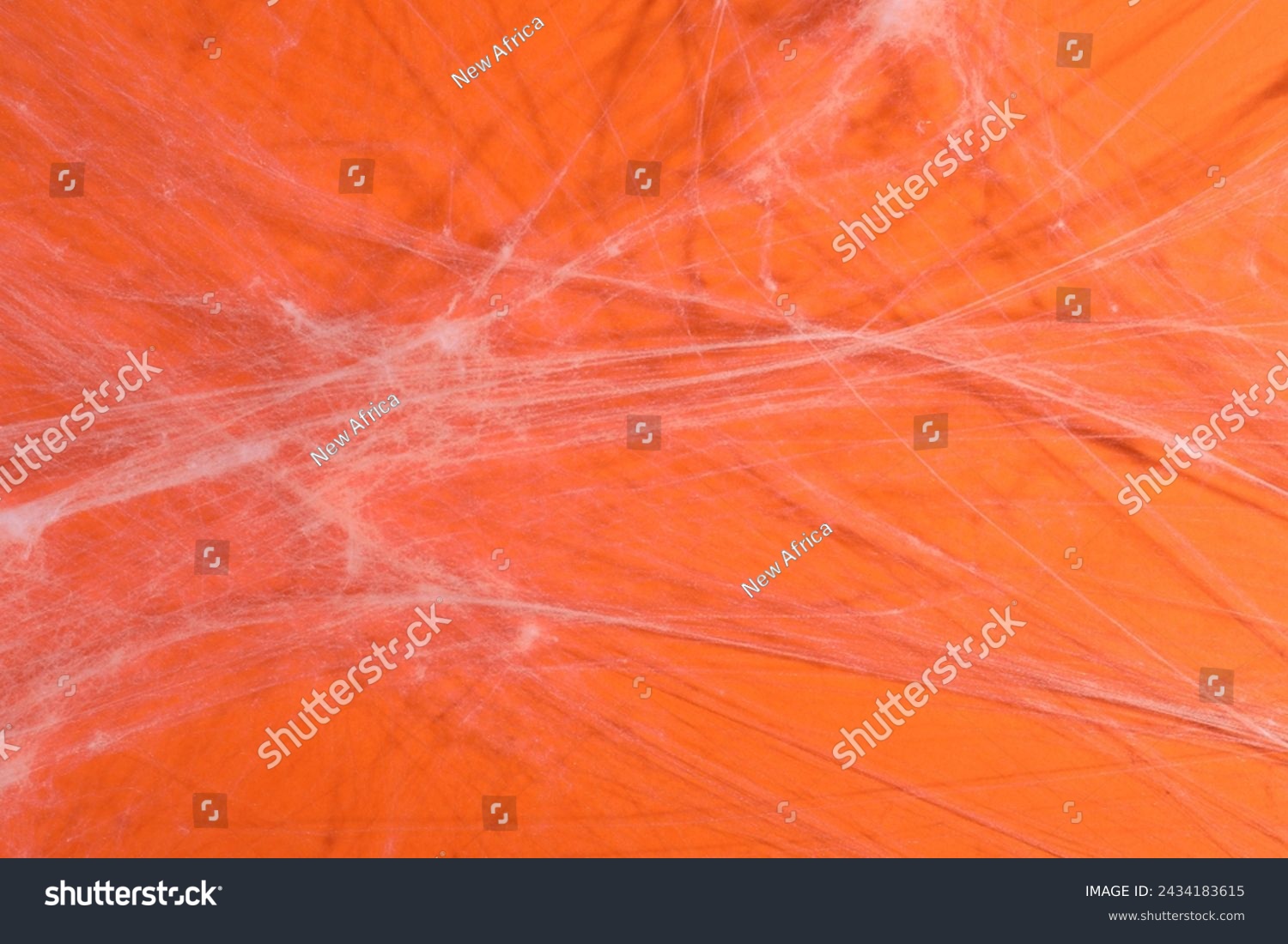 Creepy white cobweb hanging on orange background, closeup #2434183615