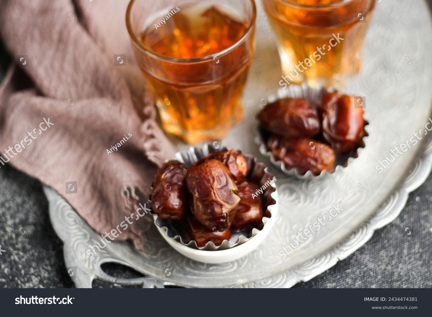 Dates or dried dates and hot tea on silver tray.  #2434474381