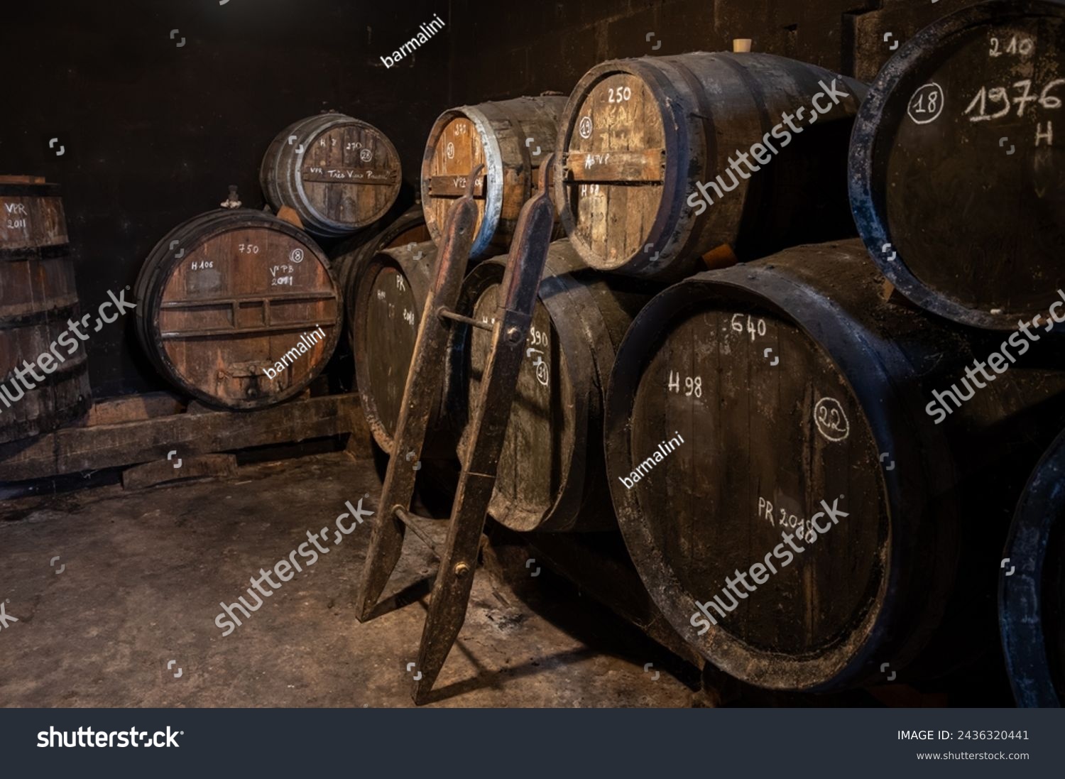 Aging process of cognac spirit in old dark French oak barrels in cellar in distillery house, Cognac white wine region, Charente, Segonzac, Grand Champagne, France #2436320441
