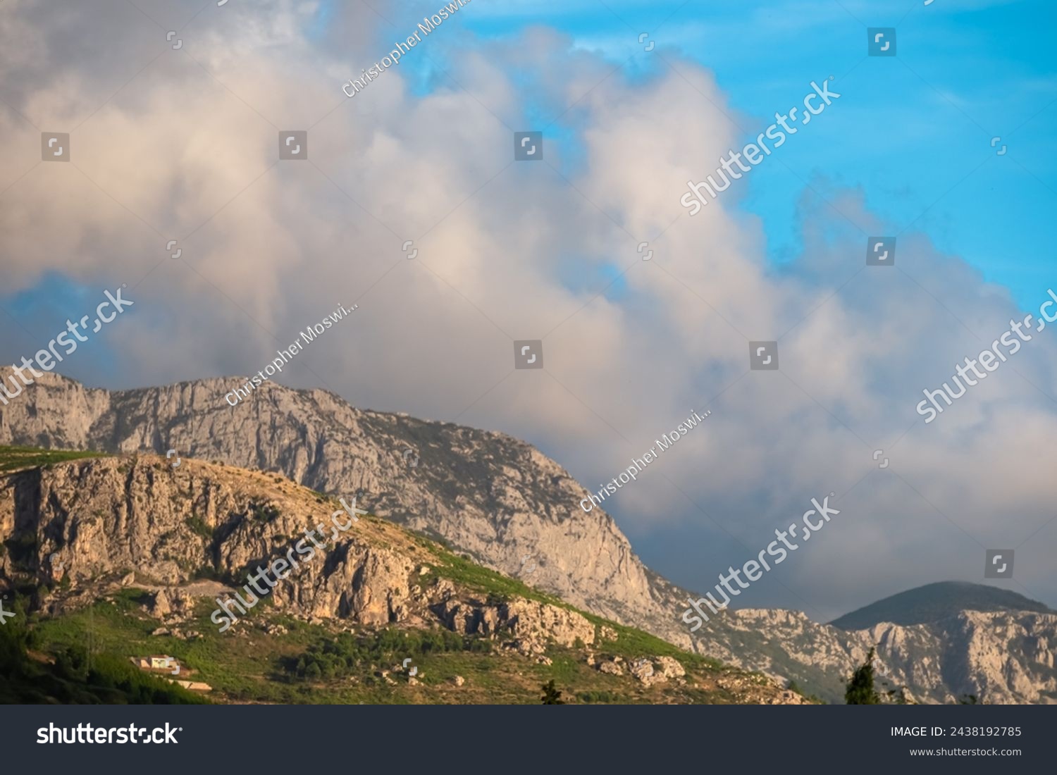 Scenic sunset view of cloud covered Biokovo mountains in majestic Dinaric Alps seen from Makarska, Split-Dalmatia, Croatia, Europe. Coastline of Makarska Riviera. Hiking in the Balkans. Wanderlust #2438192785