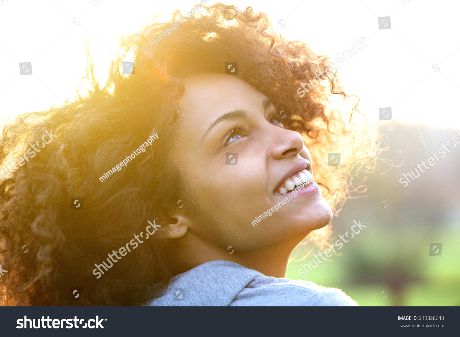 Close up portrait of a beautiful young african american woman smiling and looking up #243828643
