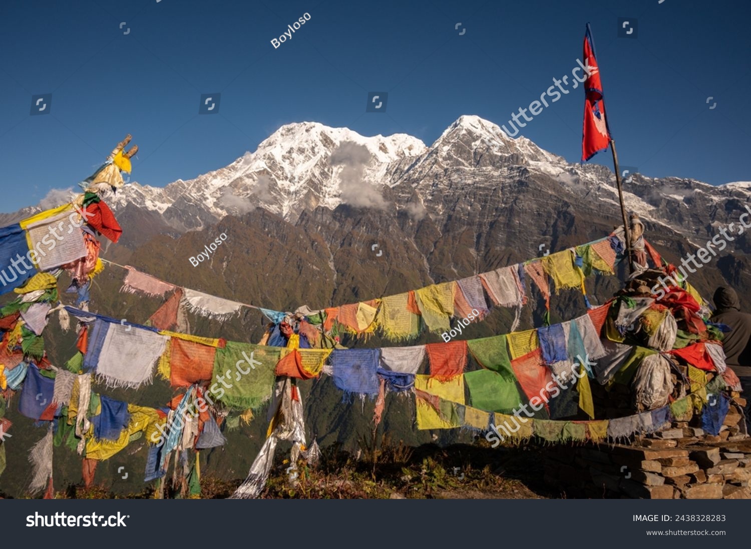 Nepali flag with beautiful view of Mt.Annapurna South (7,219 m) and Mt.Hiunchuli (6,441 m) seen from Mardi Himal view point in the Annapurna region of Nepal. #2438328283