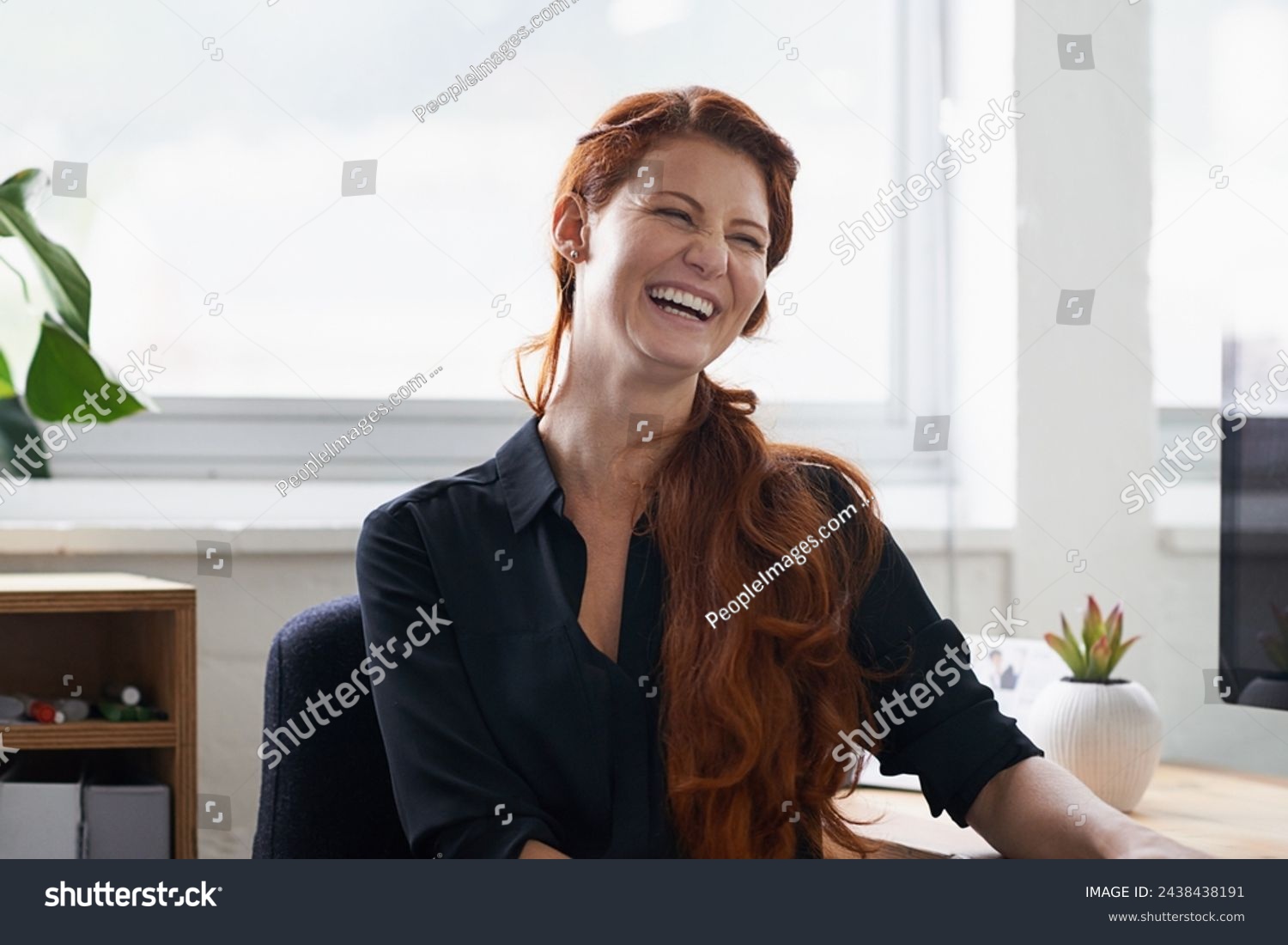 Businesswoman, laughing and office desk as entrepreneur at tech startup for small business, professional or funny. Female person, smile and confidence for company growth or humor, joke or workplace #2438438191