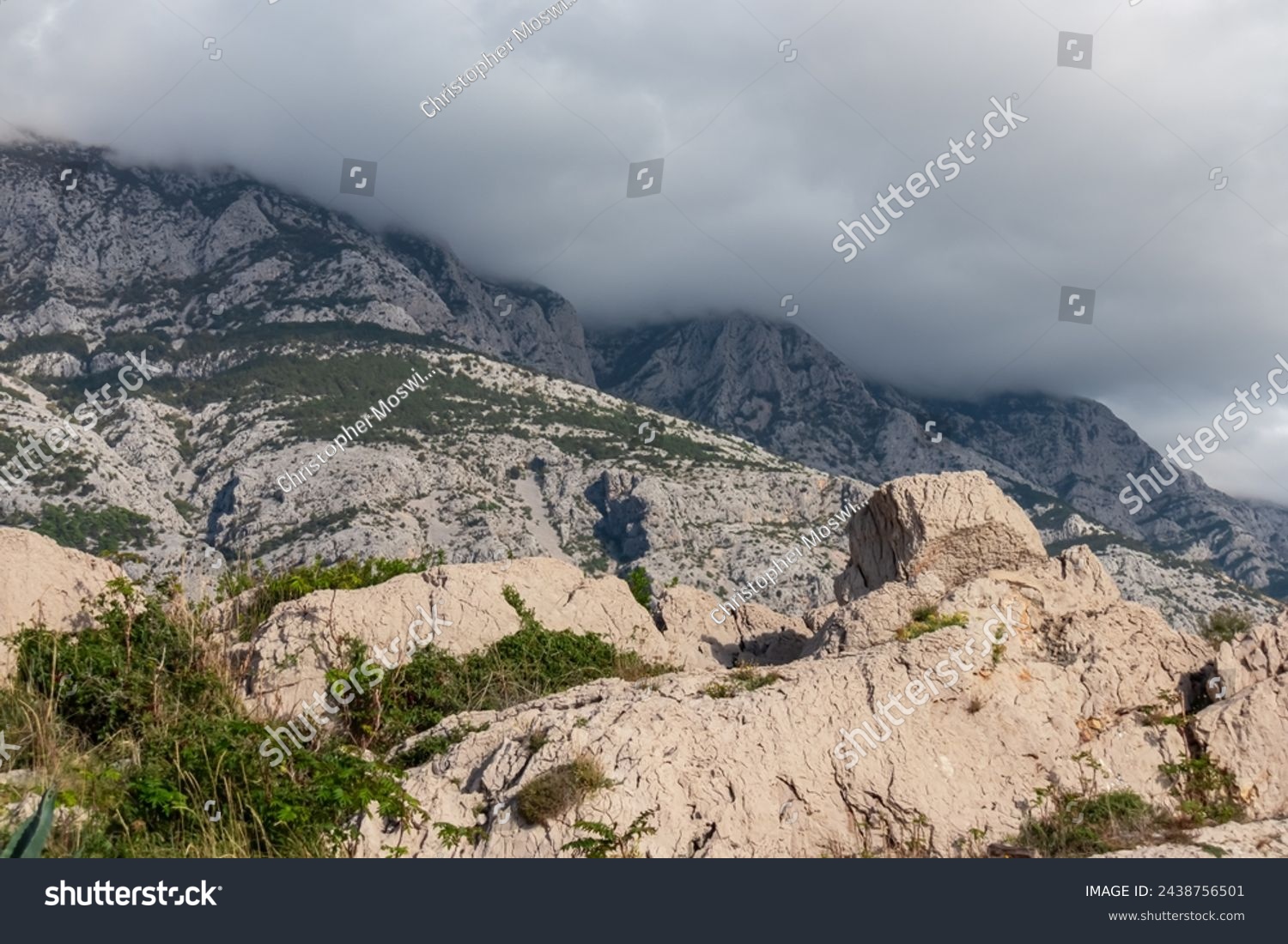Panoramic view of cloud covered Biokovo mountain range in majestic Dinaric Alps seen from Makarska, Split-Dalmatia, Croatia, Europe. Coastline of Makarska Riviera. Hiking in the Balkans. Wanderlust #2438756501