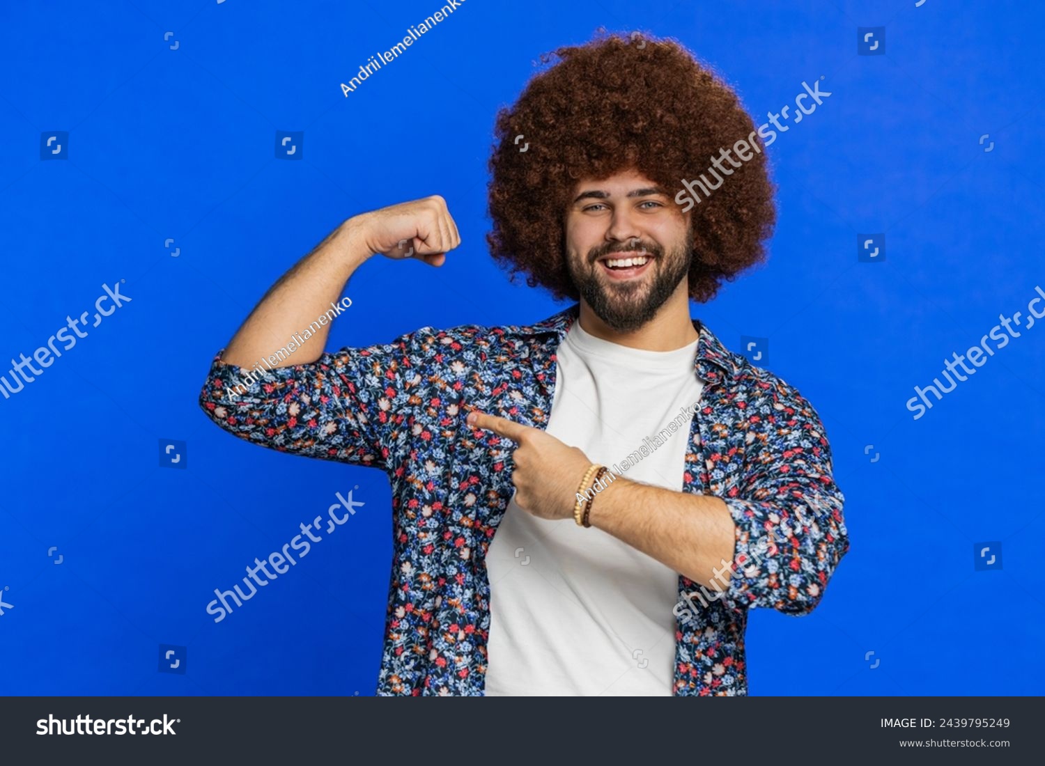 I am strong and independent. Man with Afro hairstyle wig showing biceps and looking confident, feeling power strength to fight for rights, energy to gain success win. Guy isolated on blue background #2439795249