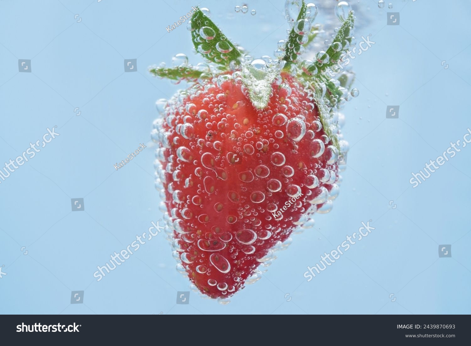 Macro shot of a strawberry in sparkling mineral water. Close up on details of a berry and water bubbles.  #2439870693