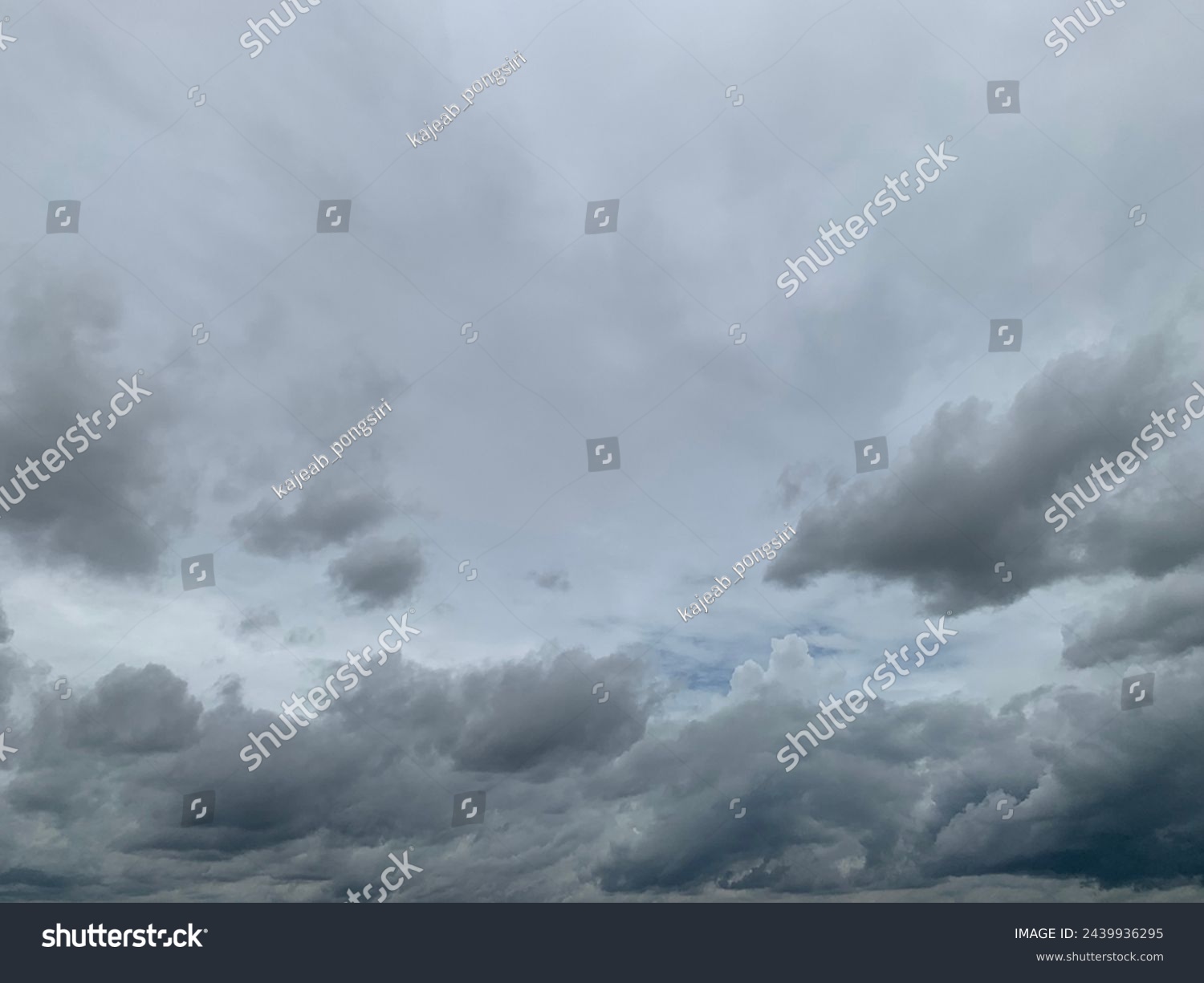 Gray nimbostratus clouds roll in layers above the sky, carried by the wind Long continuous rain in Trang Province, Thailand. No focus #2439936295