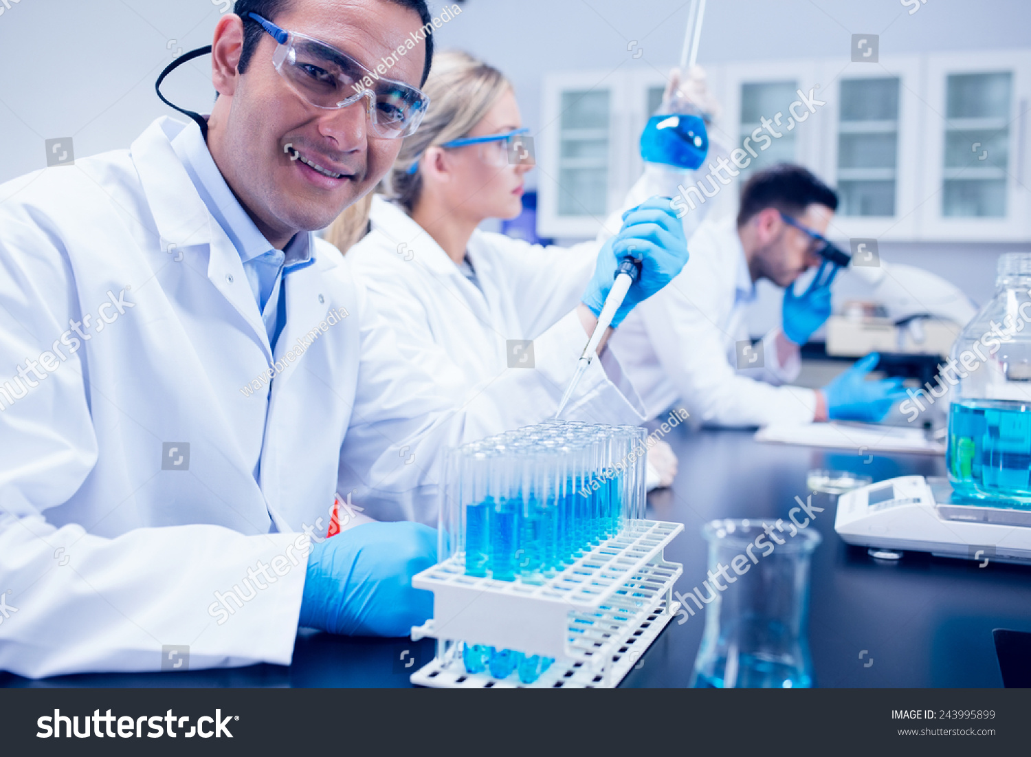 Science student using pipette in the lab to fill test tubes at the university #243995899