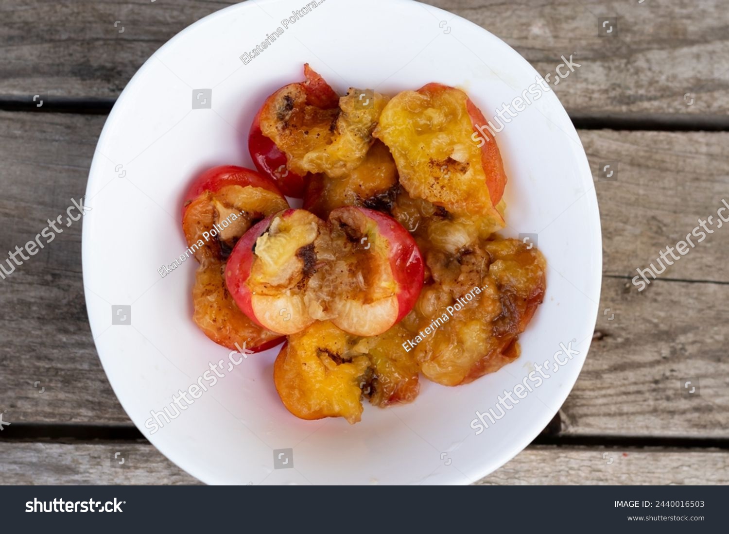 Wormy apricots on plates. Rotten apricots #2440016503