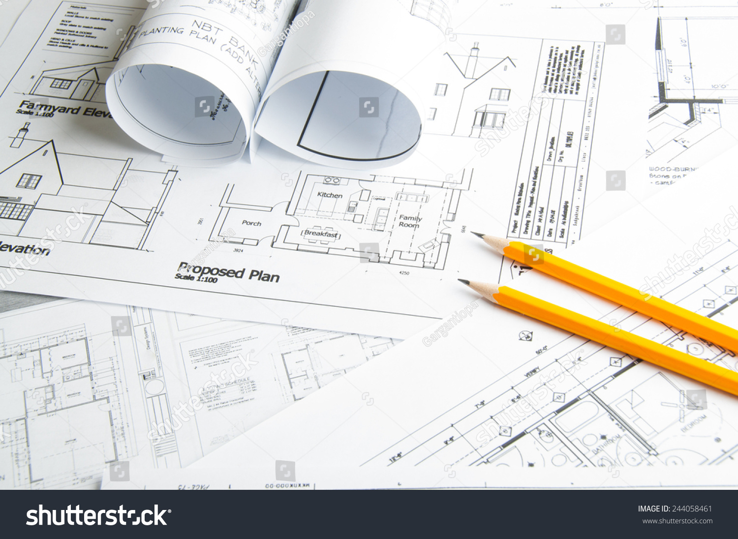 Architectural blueprints and blueprint rolls and two yellow pencils #244058461