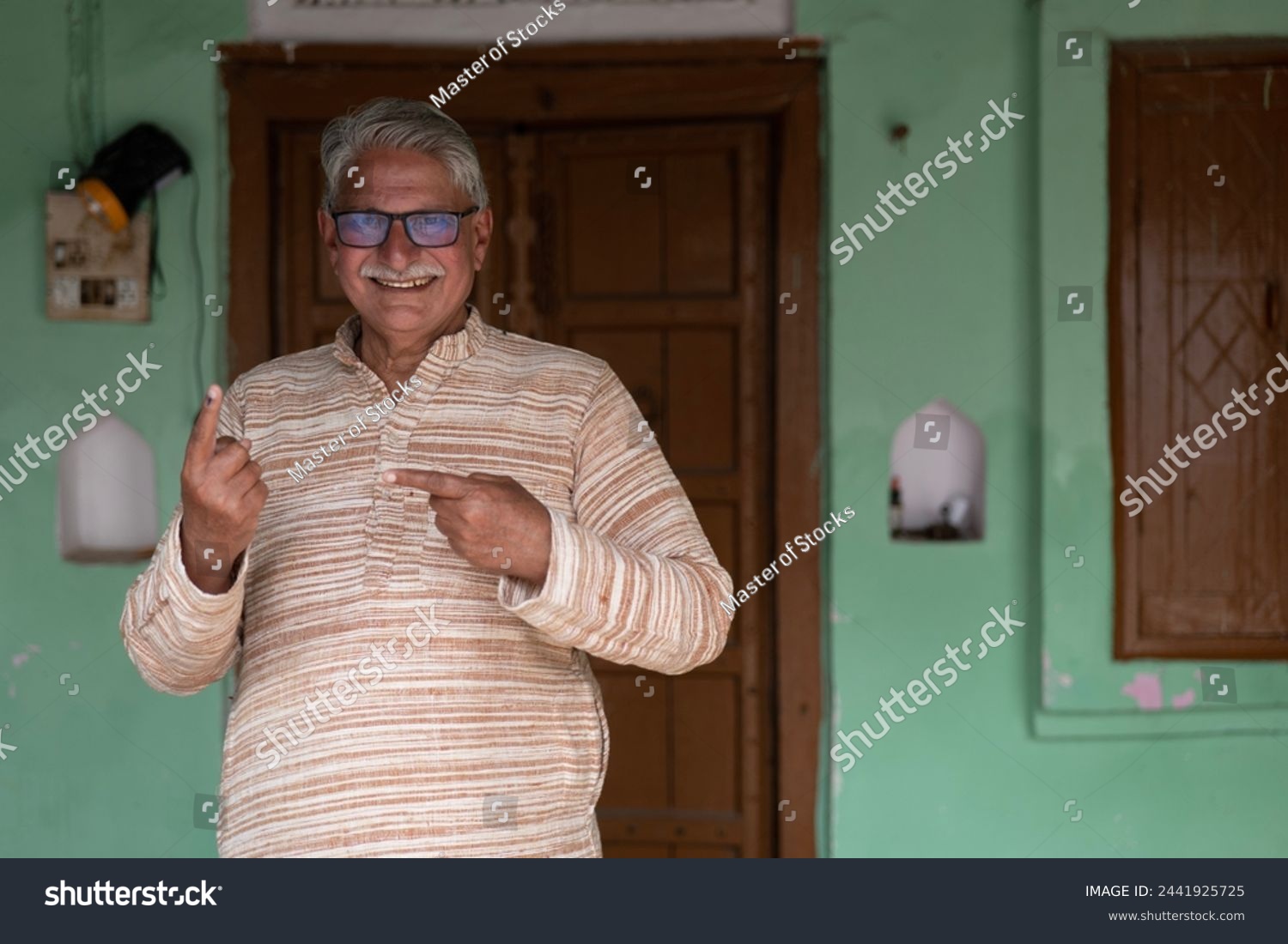 Indian senior rural man showing finger for voting #2441925725