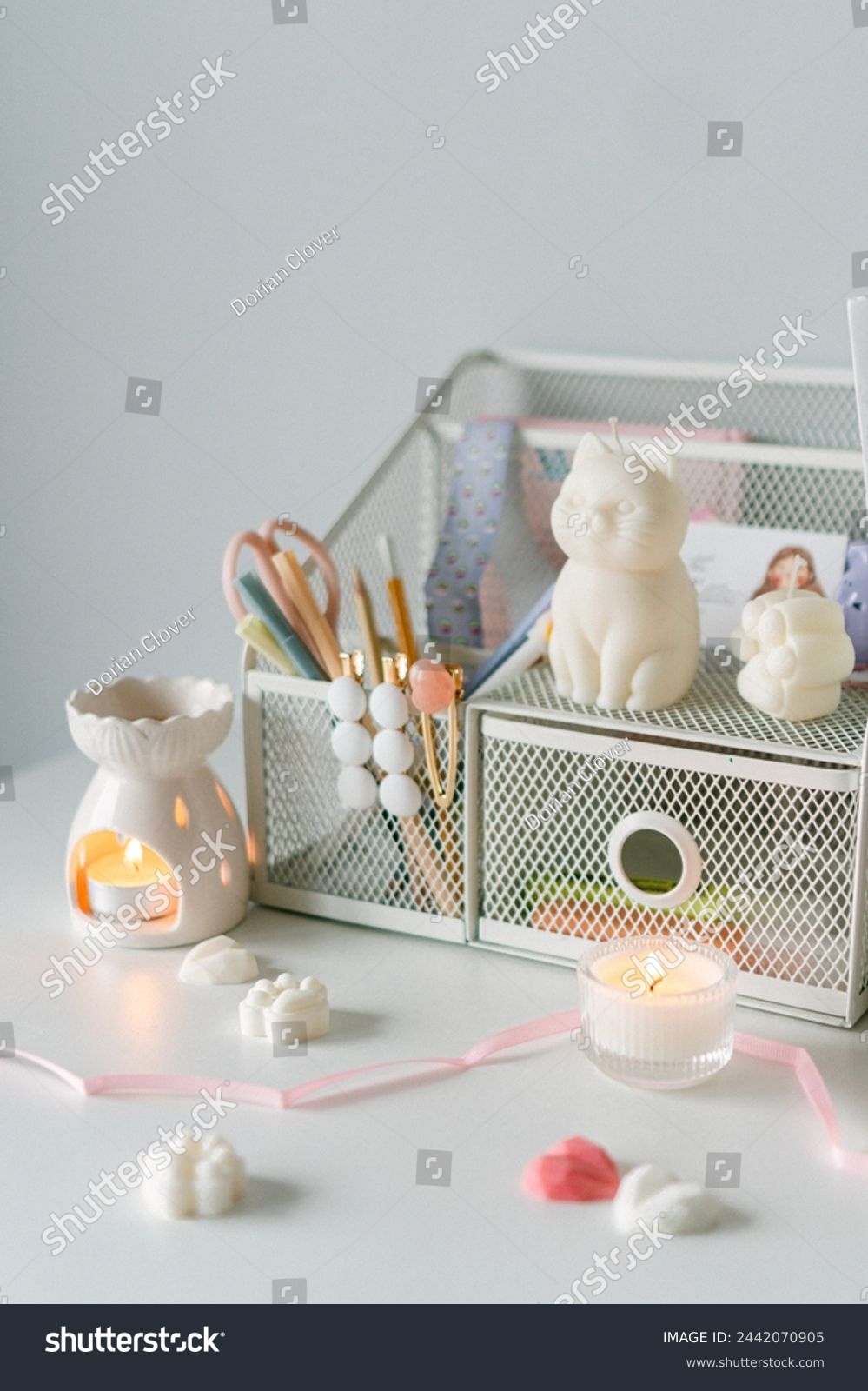 A charming workspace accented with a whimsical cat figurine, elegant stationery, and warm candlelight, exuding tranquility and style. #2442070905