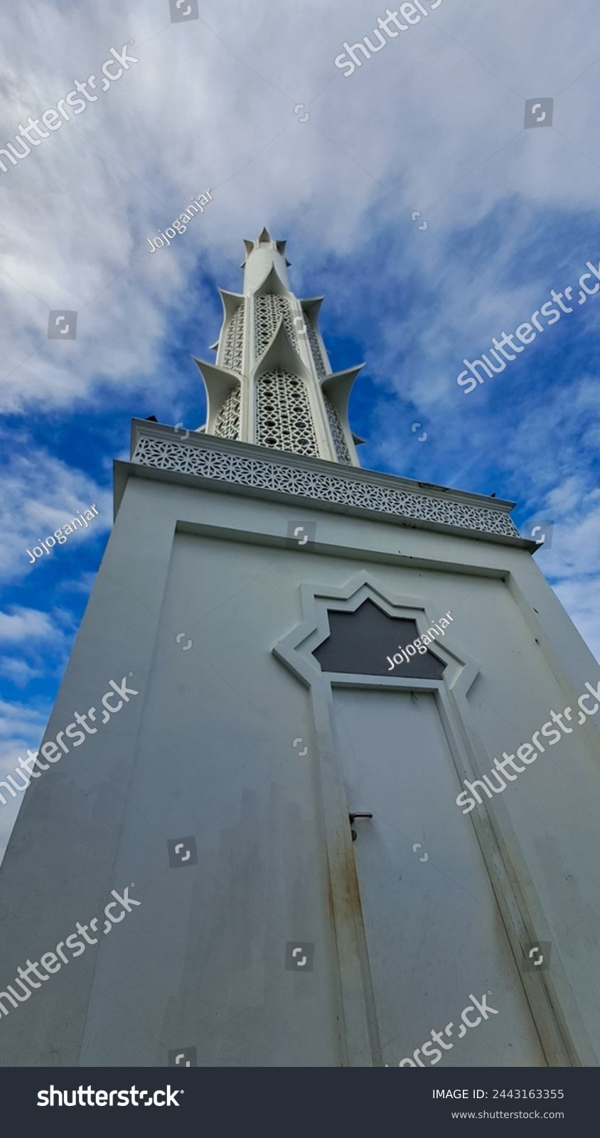 the mosque's minaret towers high into the sky #2443163355