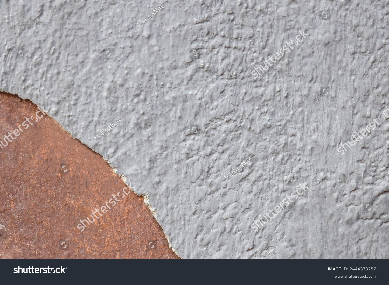 Colorful grey-brown wall surface of an old building with crumbling plaster as a textured background. Copy space. Selective focus. #2444373257