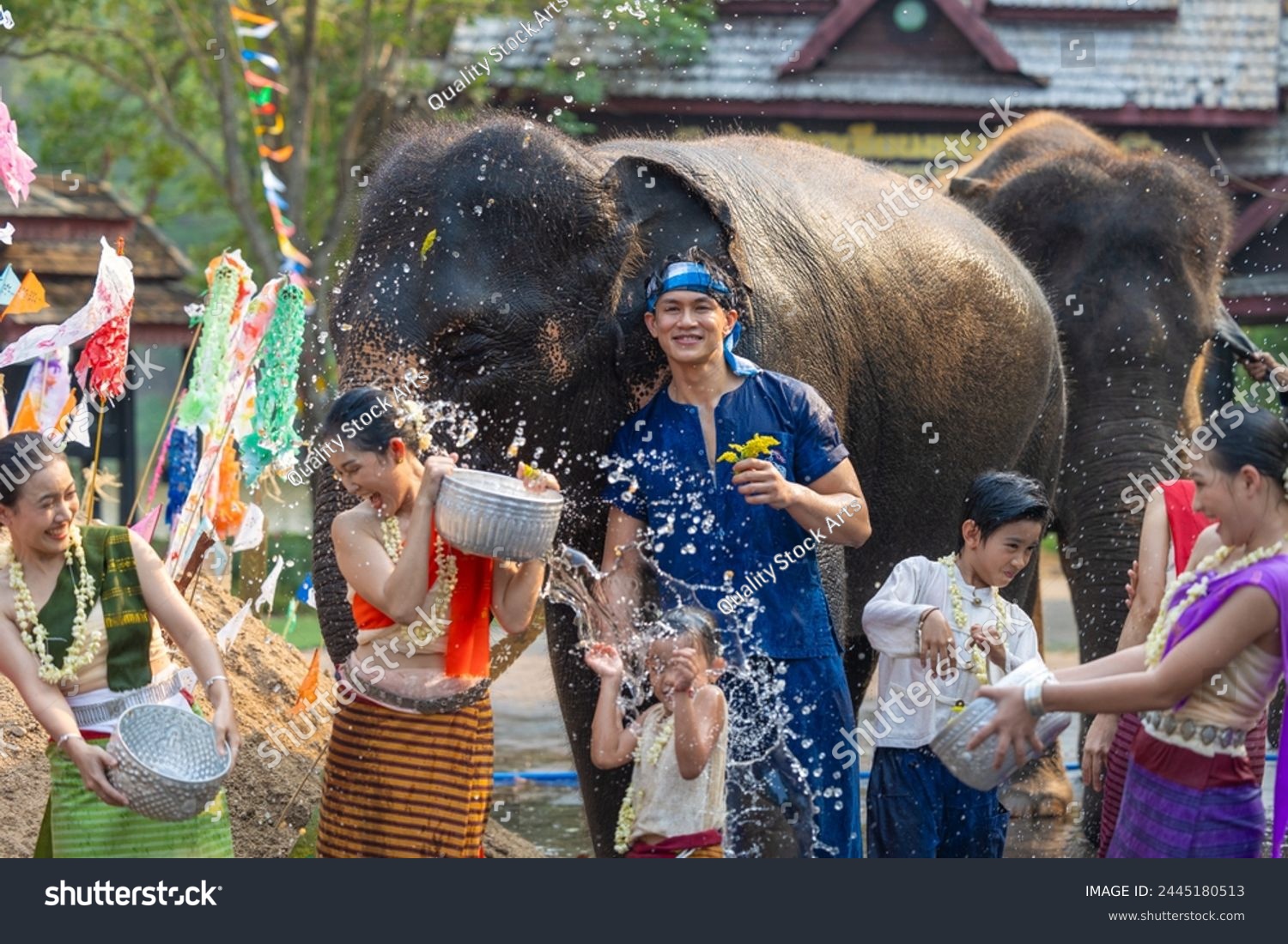 Songkran festival. Northern Thai people in Traditional clothes dressing splashing water together in Songkran day cultural festival with elephant background. #2445180513