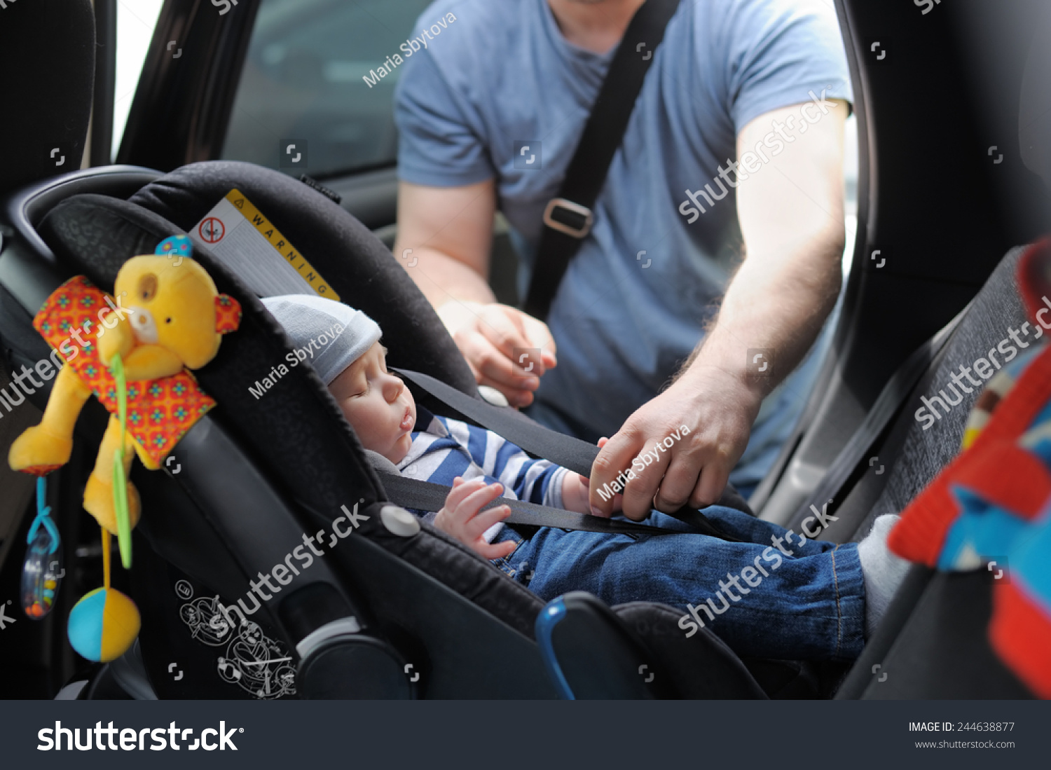 Father fasten his little son in car seat #244638877