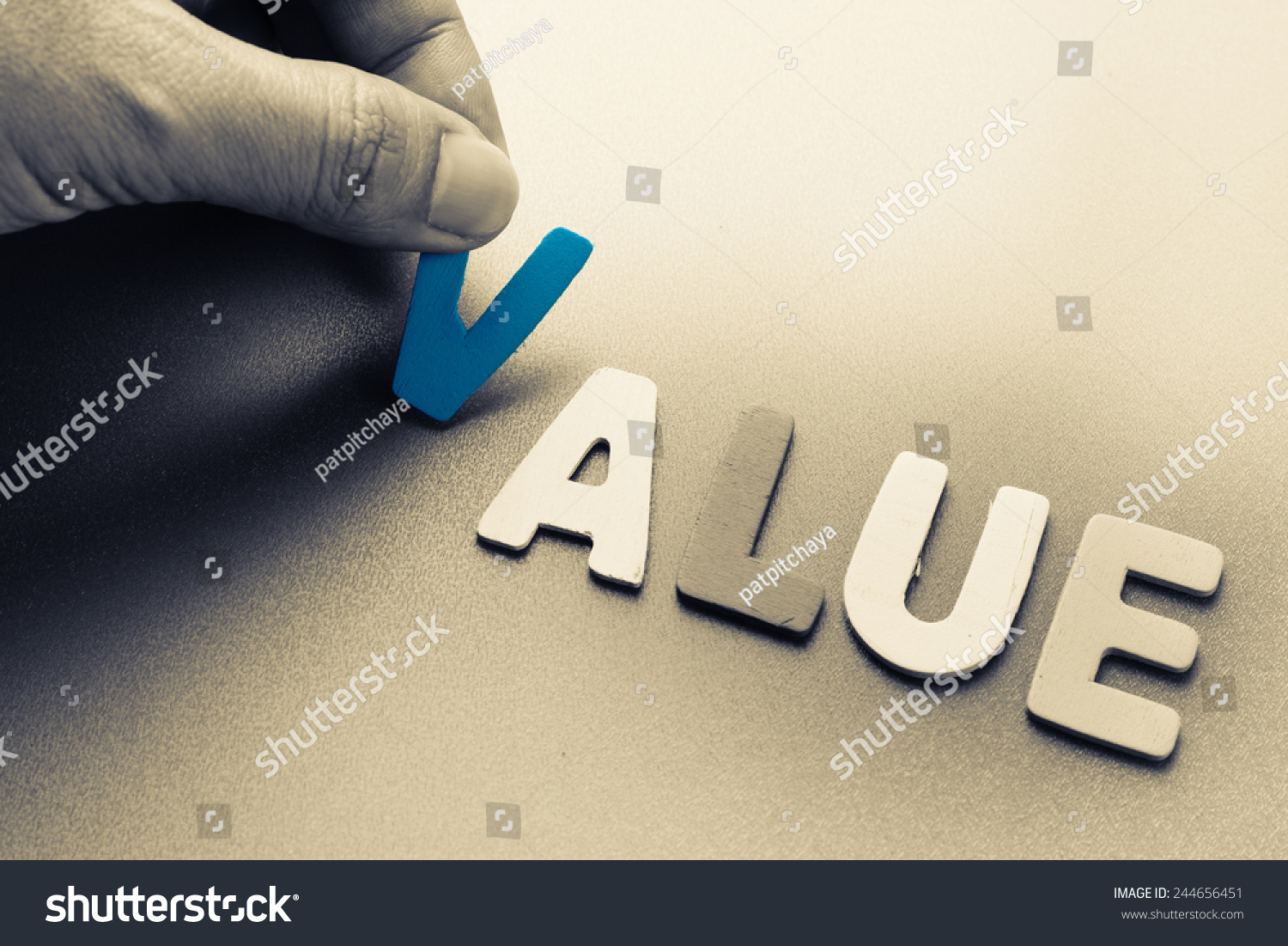 Hand arrange wood letters as Value word #244656451
