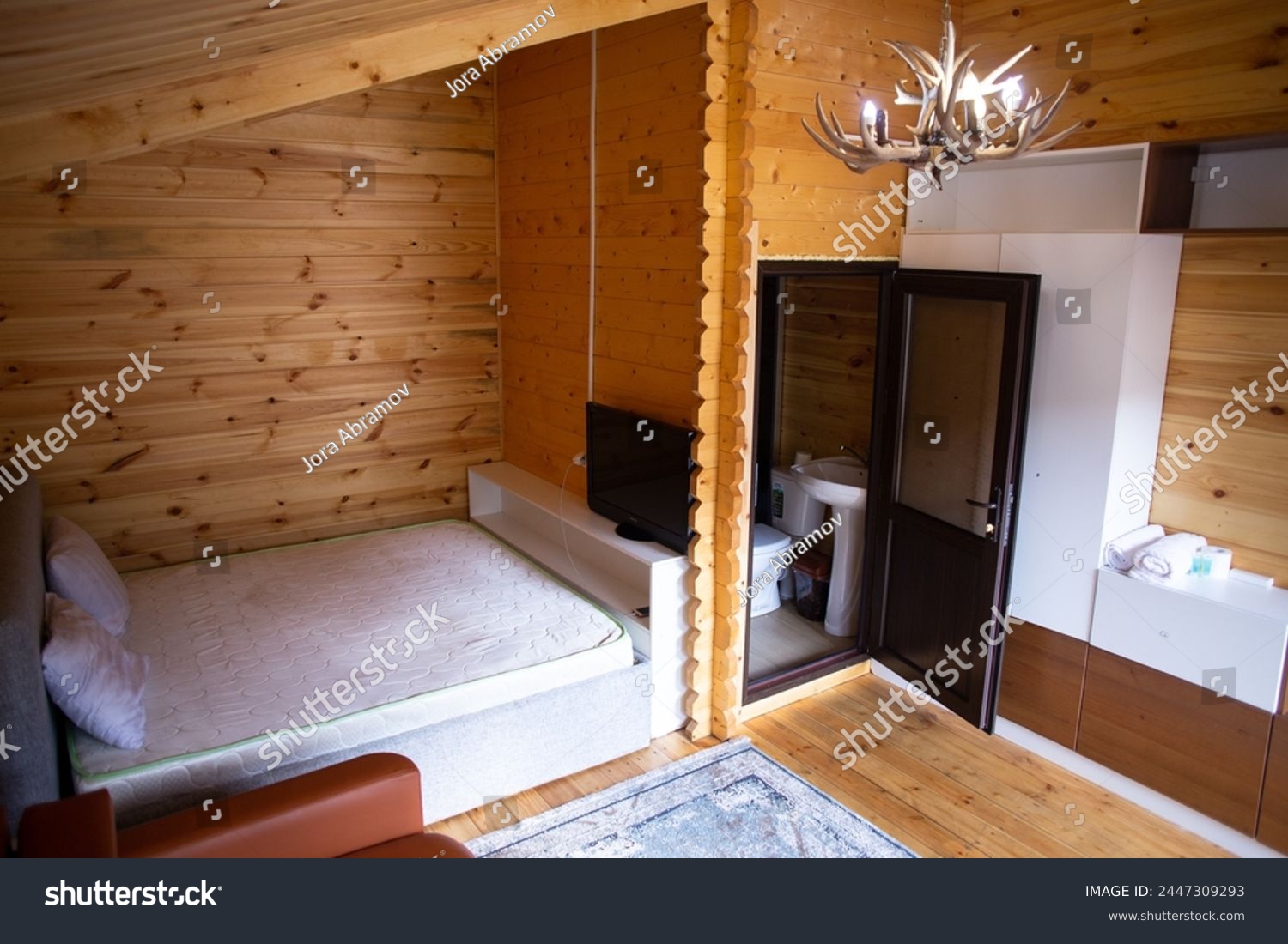 The cabins interior is paneled with wood and furnished with a bed, sofa, and armoire. A bearskin rug adds a touch of warmth to the space. #2447309293