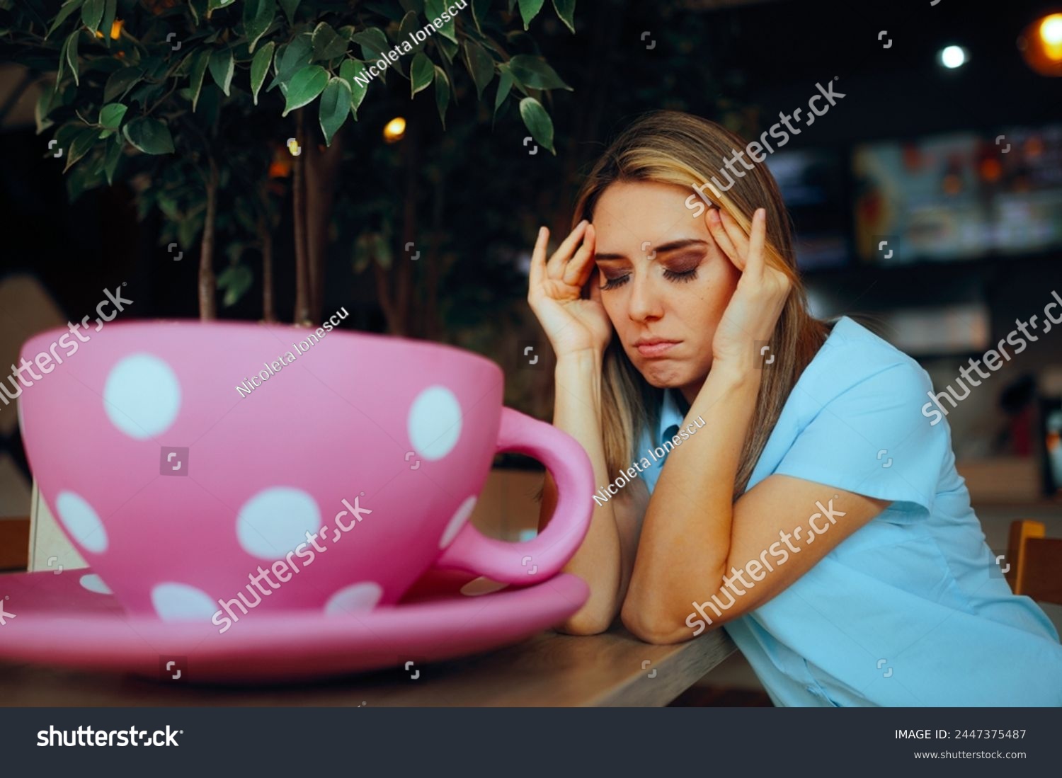
Tired Woman Having a Large Cup of Coffee in a Cafeteria. Exhausted person trying to start the day with more energy
 #2447375487