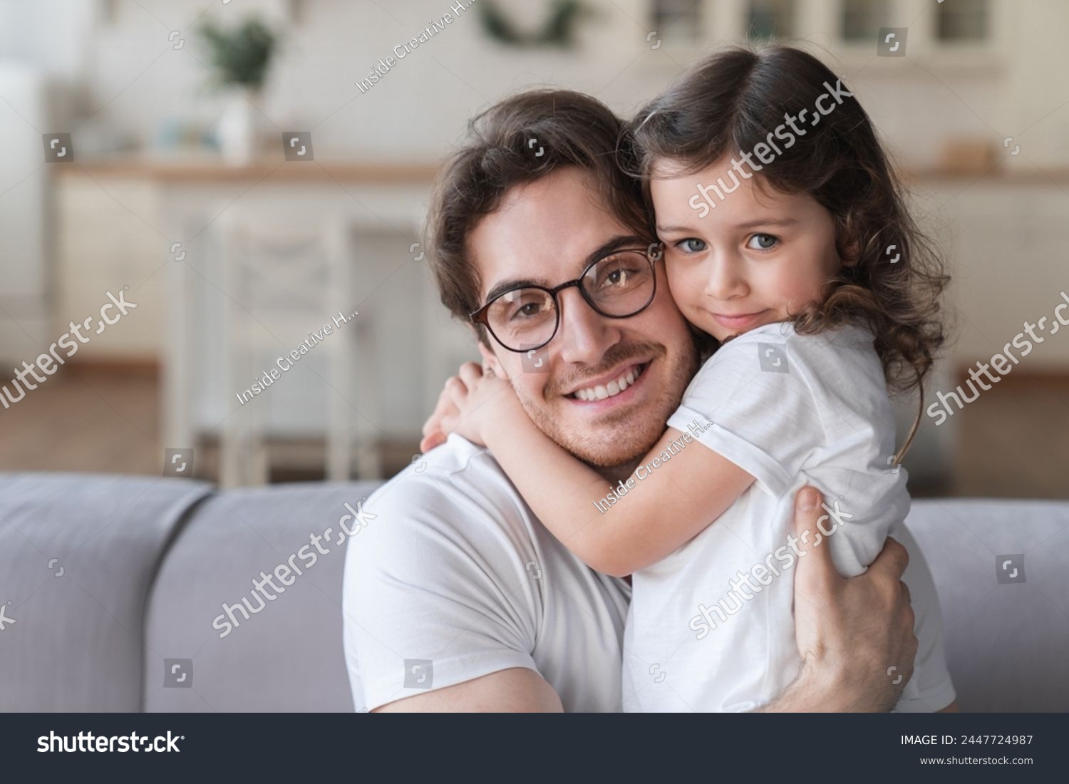 Young handsome father hugging his little small child daughter at home. Family time together. Parenthood and fatherhood, happy father`s day! I love you, dad! #2447724987
