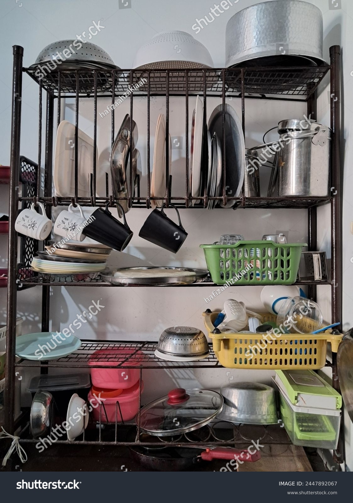 Arrangement of plates on an iron plate rack typical of a traditional Indian kitchen  #2447892067