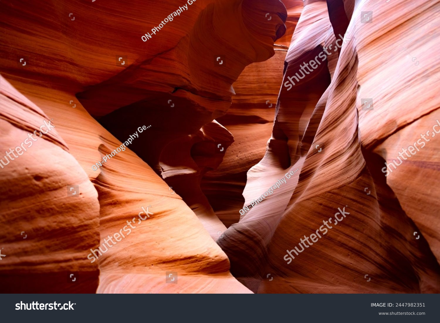 Antelope canyon in Arizona, USA is a natural wonder, magic place and tourist attraction formed by the power of erosion. Red-orange sandstone washed out by water in colorul shapes illuminated by sun. #2447982351
