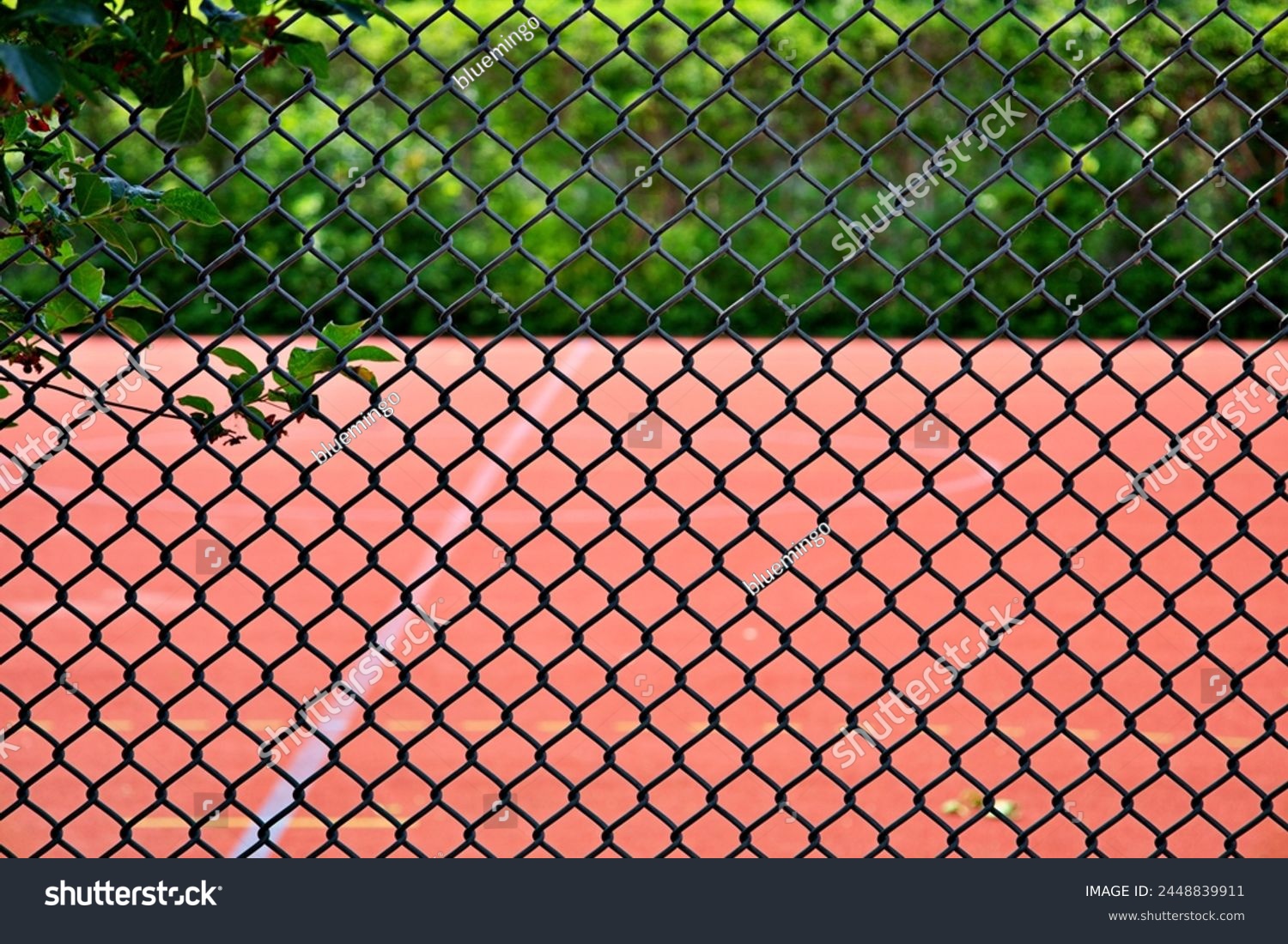 tennis court behind chainlink fence #2448839911
